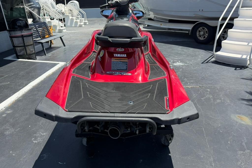 2019 Yamaha VX Limited jet ski, red, parked on pavement near boats.