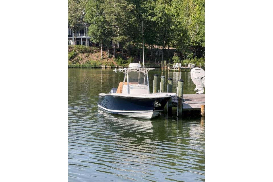 2014 Southport 29 FE boat docked on a serene lake with lush greenery.