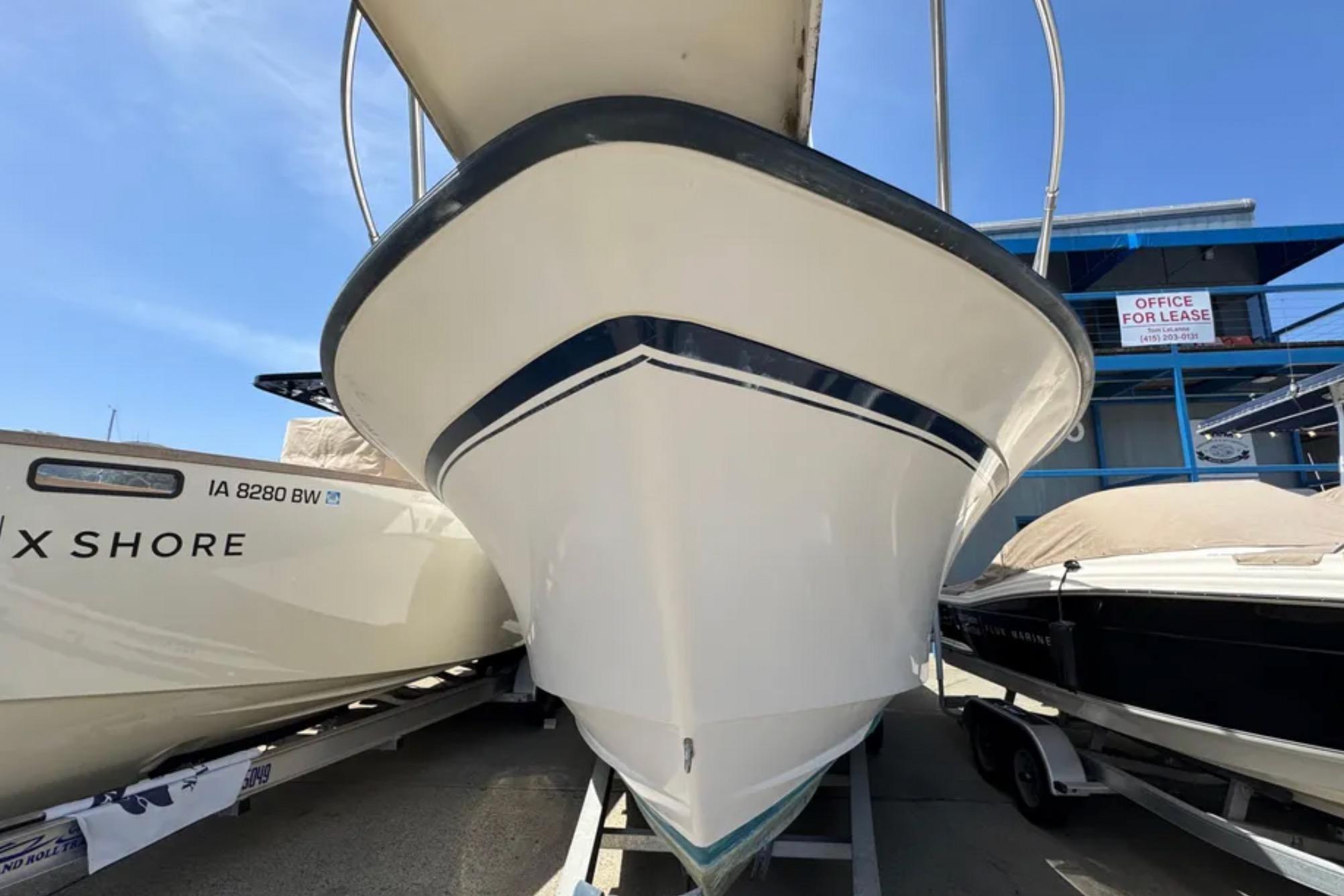 1990 Grady-White Marlin 280 boat on trailer, docked beside other vessels.