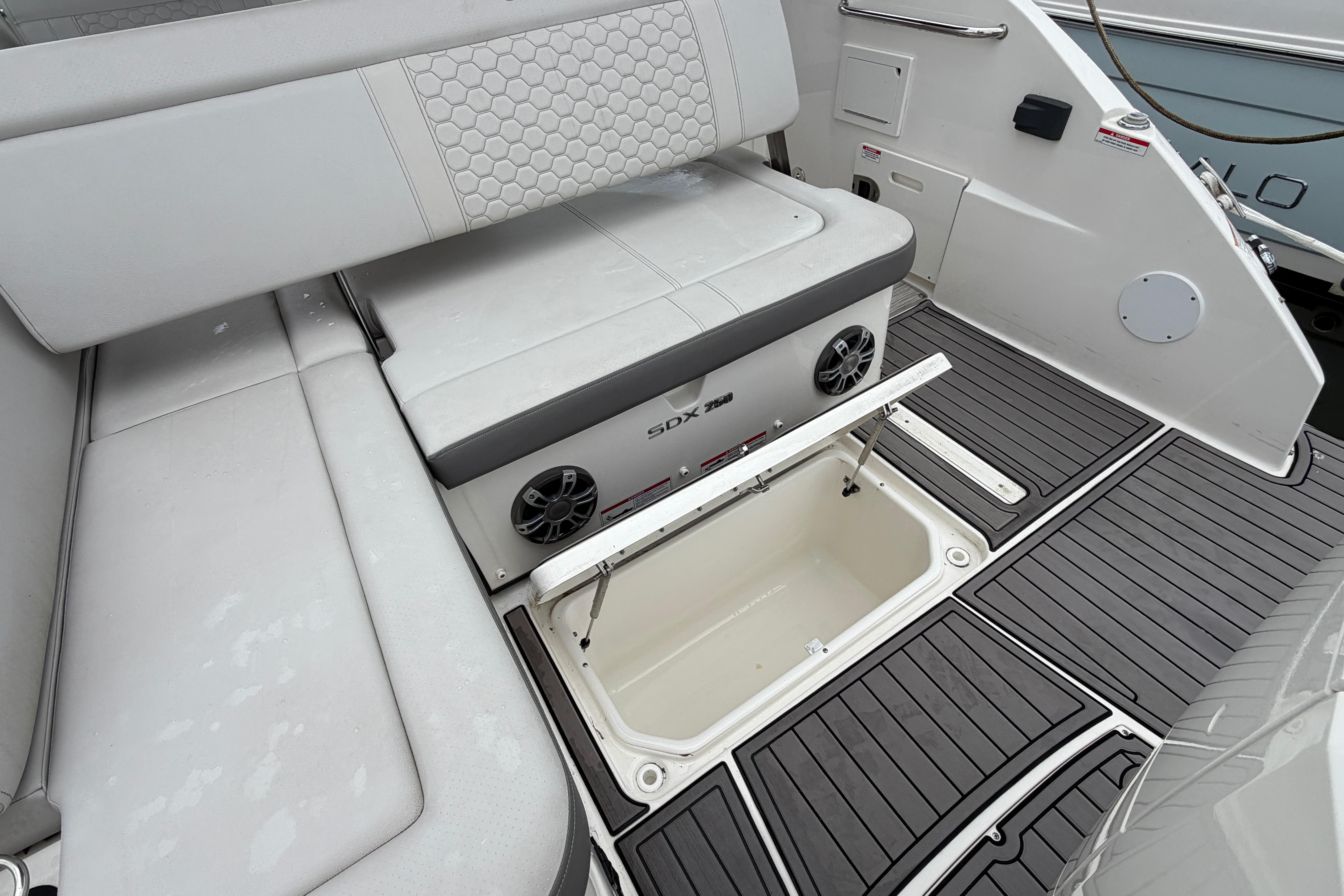 2023 Sea Ray SDX 250 Outboard boat interior with storage compartment open.