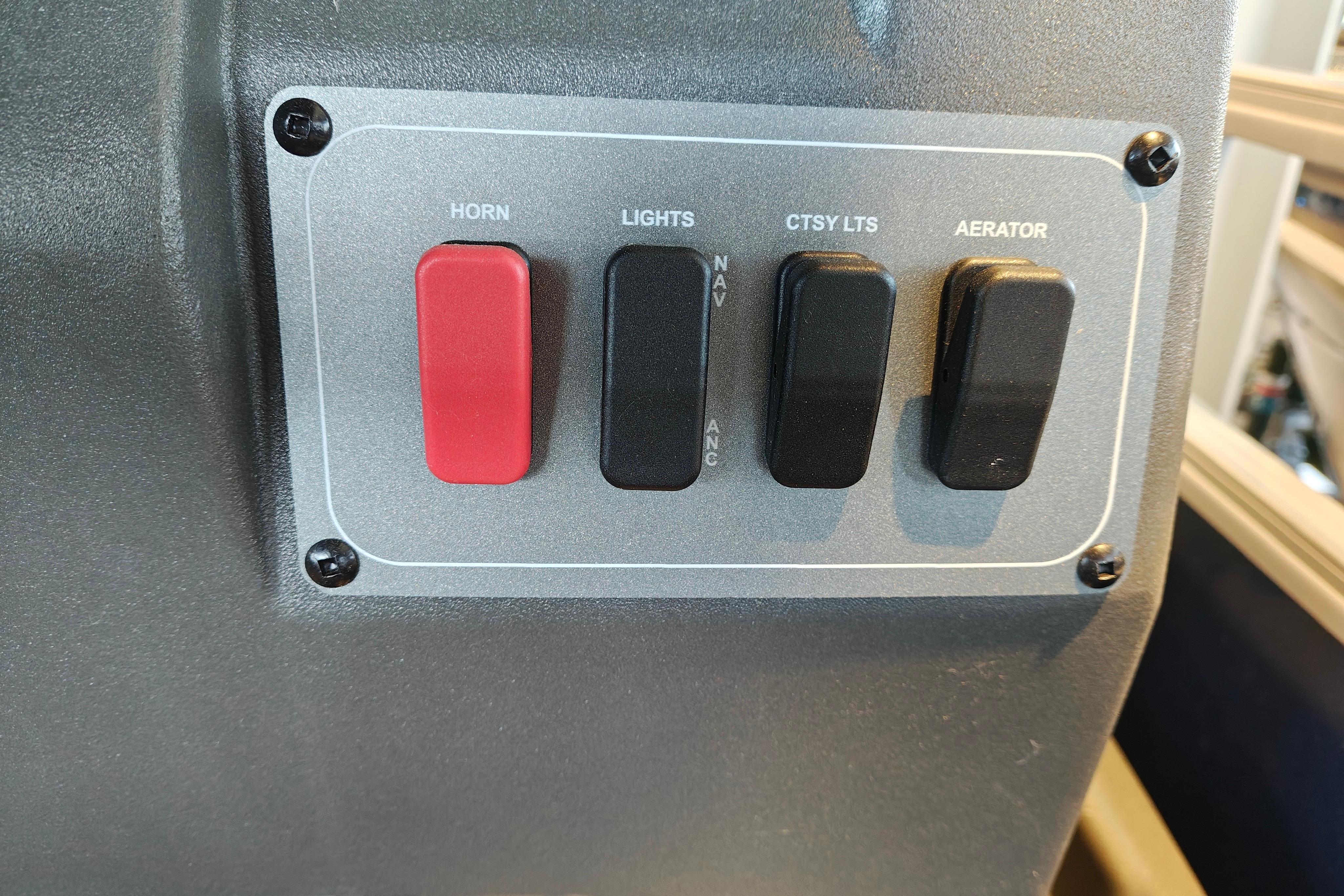 Control panel of 2026 Sun Tracker Bass Buggy 16 XL Select with switches for horn, lights, and aerator.