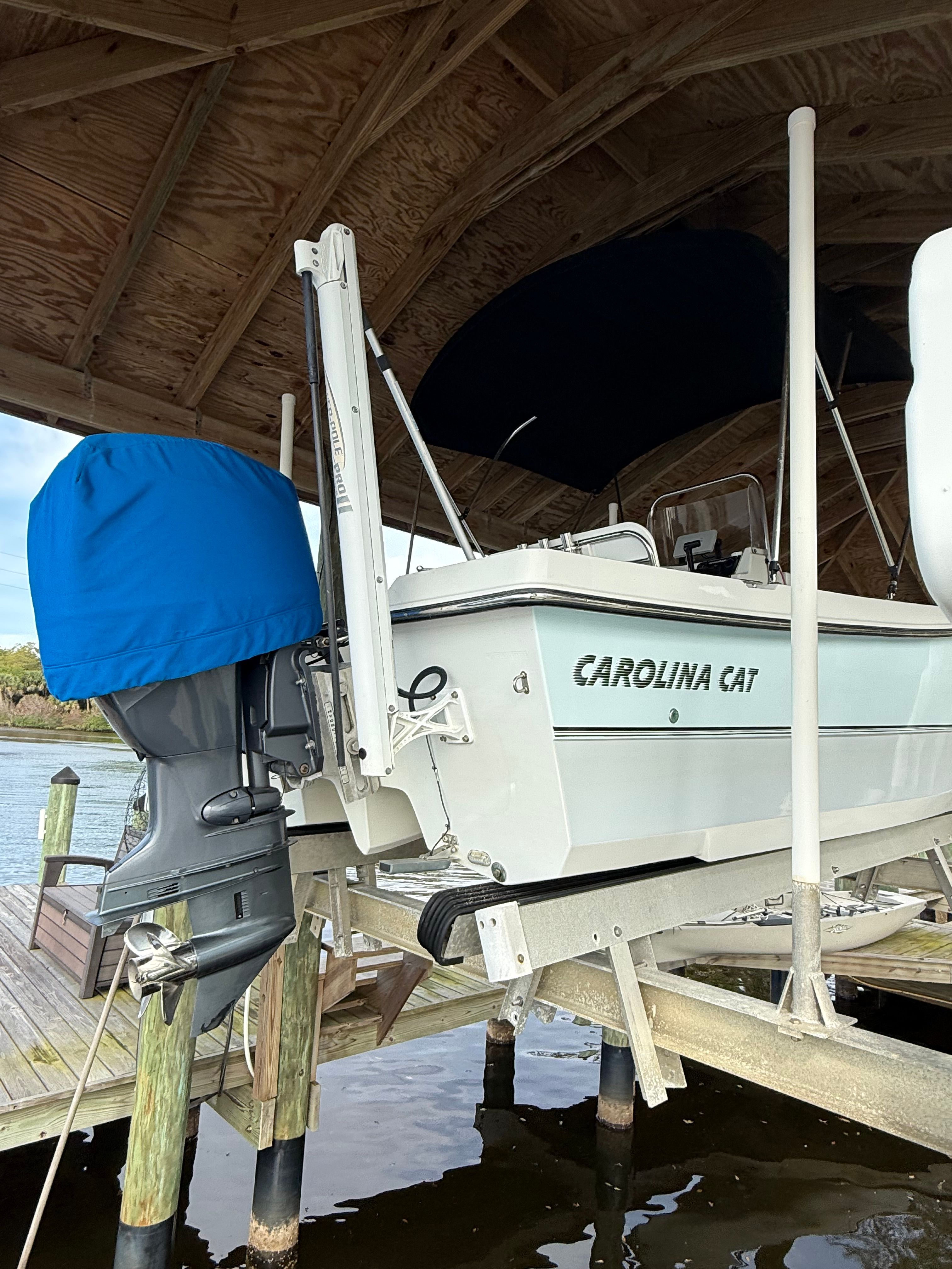 A 2011 Carolina Cat 18CC boat is on a lift above the water.