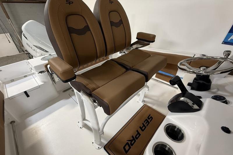 2026 Sea Pro 242 Center Console boat interior with dual brown seats and steering wheel.