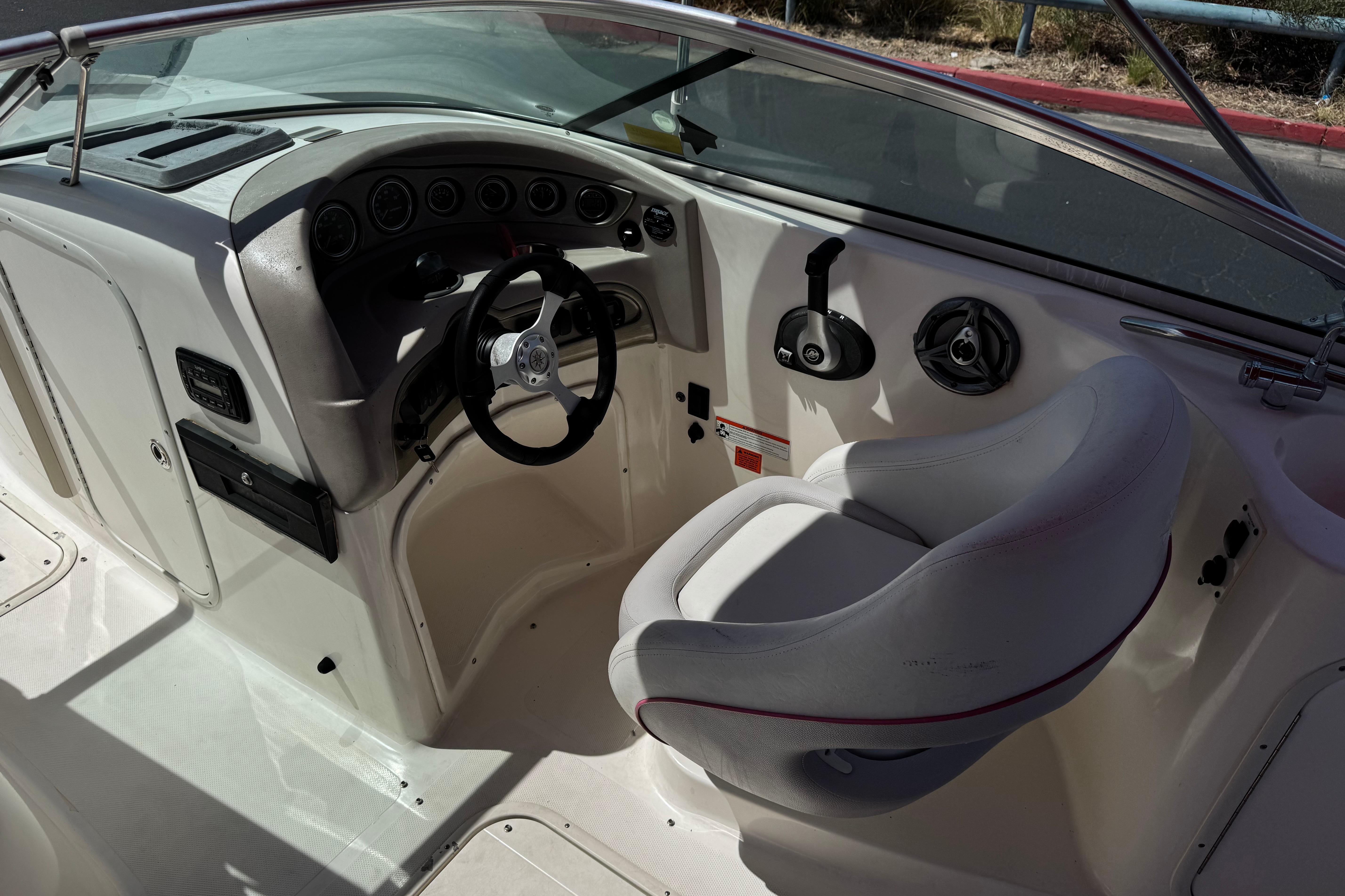 Interior of a 2010 Bryant 255 boat showing steering wheel and captain's seat.