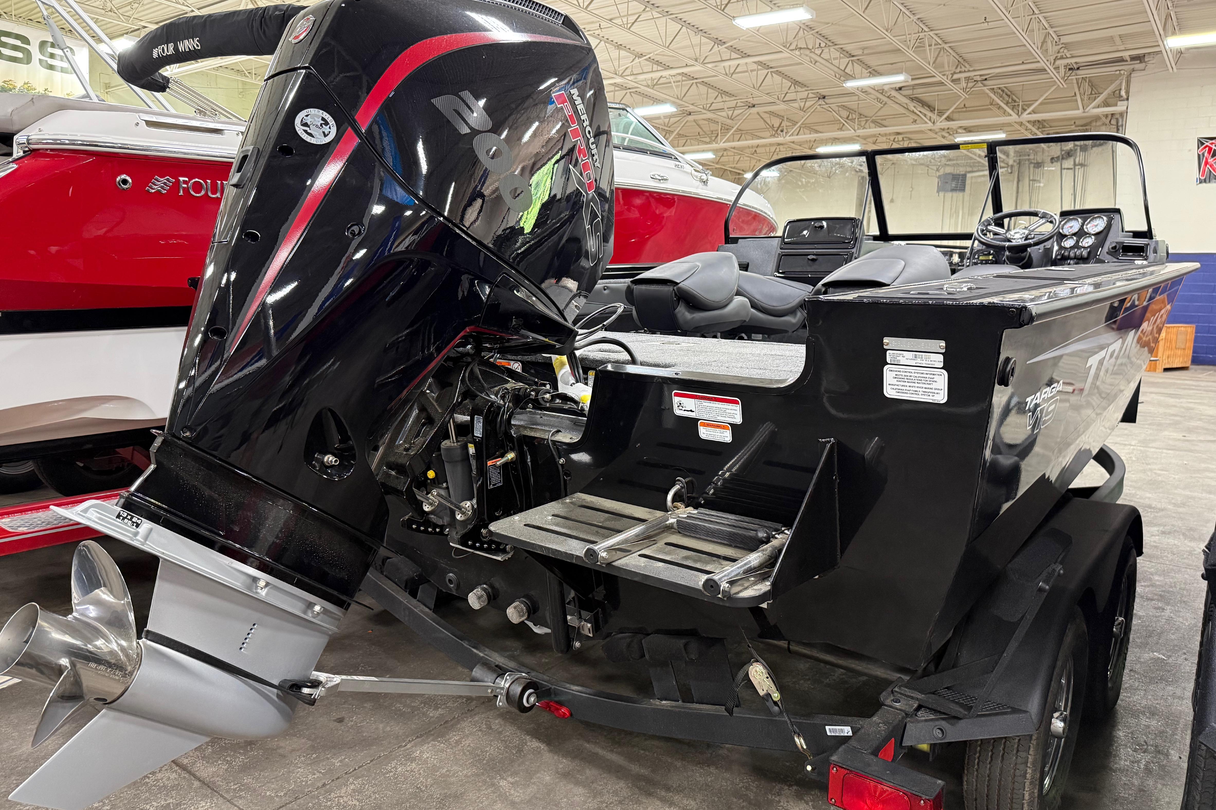 2026 Tracker Targa V-19 WT boat with powerful outboard motor in showroom.
