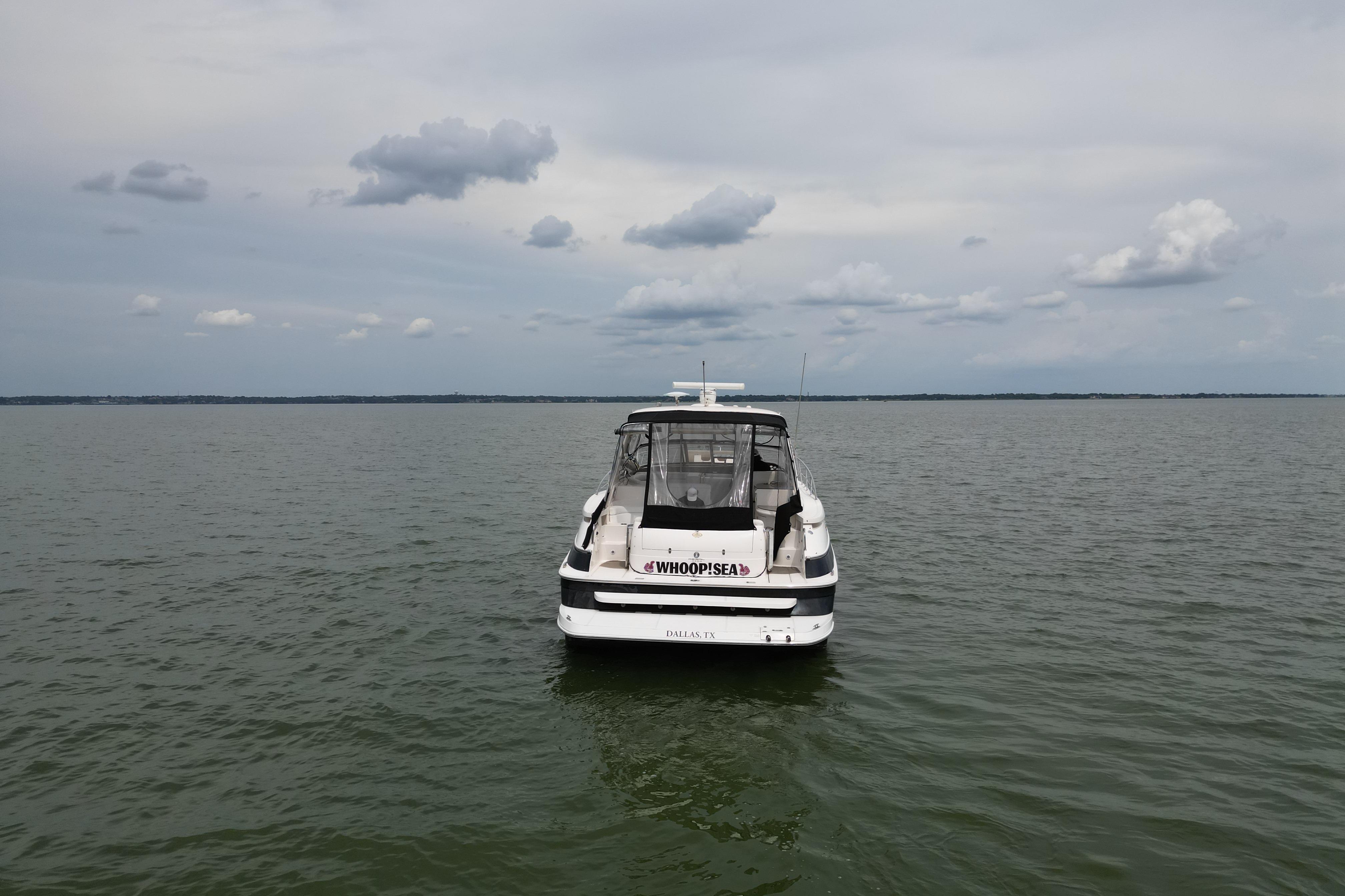 2005 Regal Commodore 4260 boat on calm water under cloudy sky.
