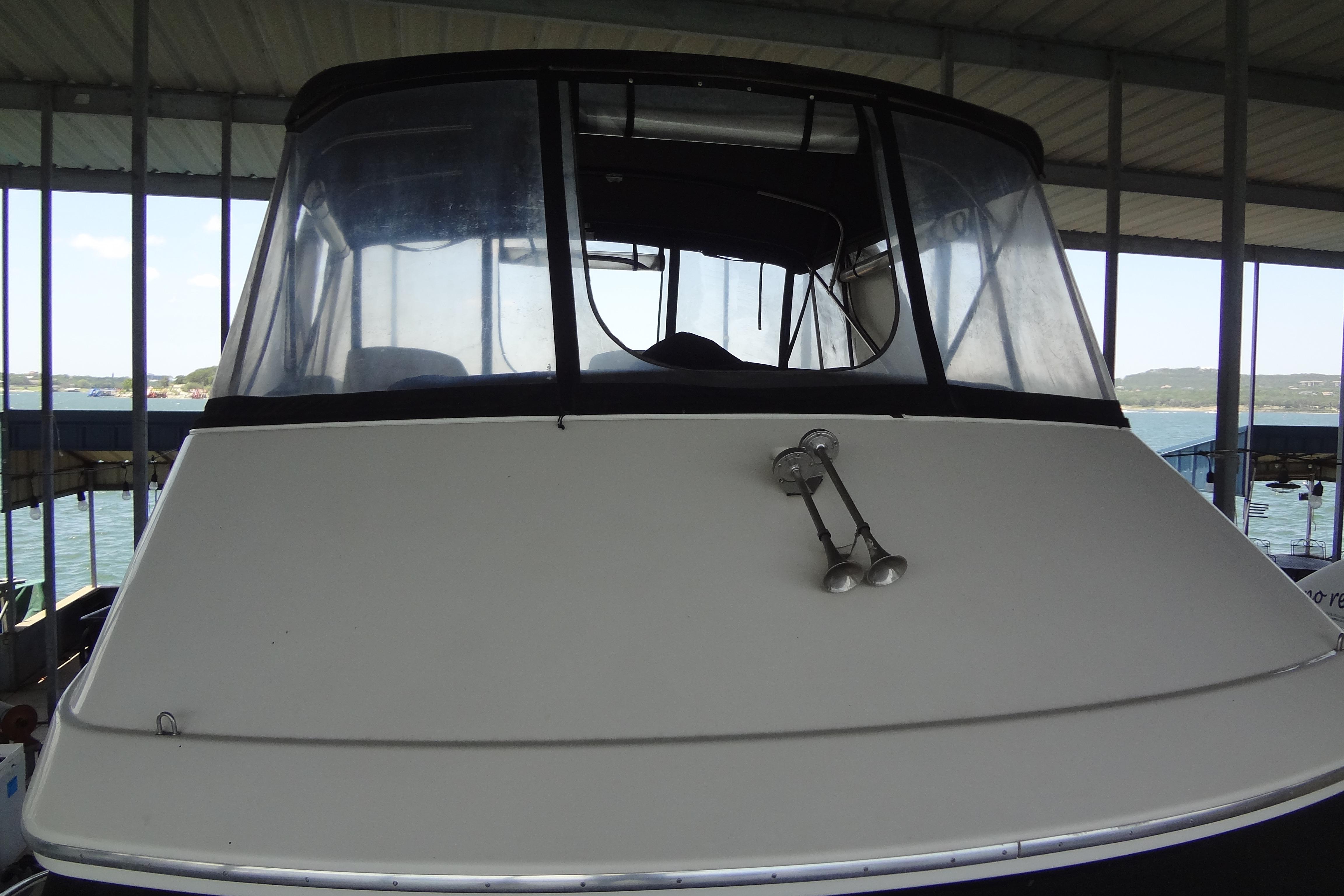 2005 Silverton 34 Convertible boat docked under a covered marina.