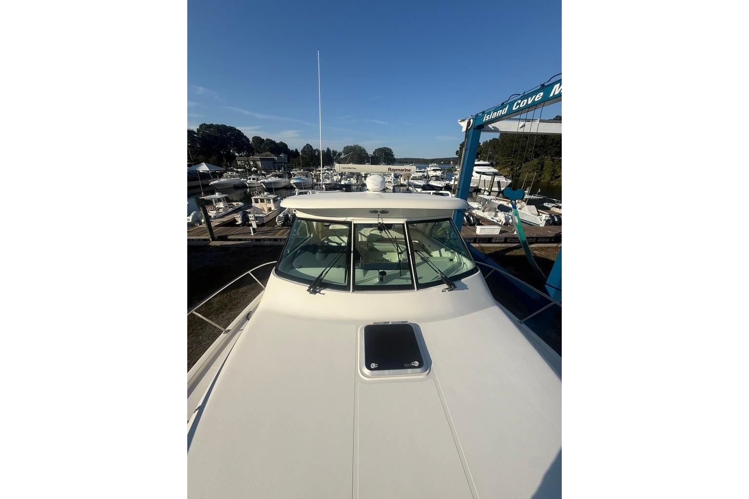 2010 Pursuit OS 375 Offshore boat docked at marina under clear blue sky.