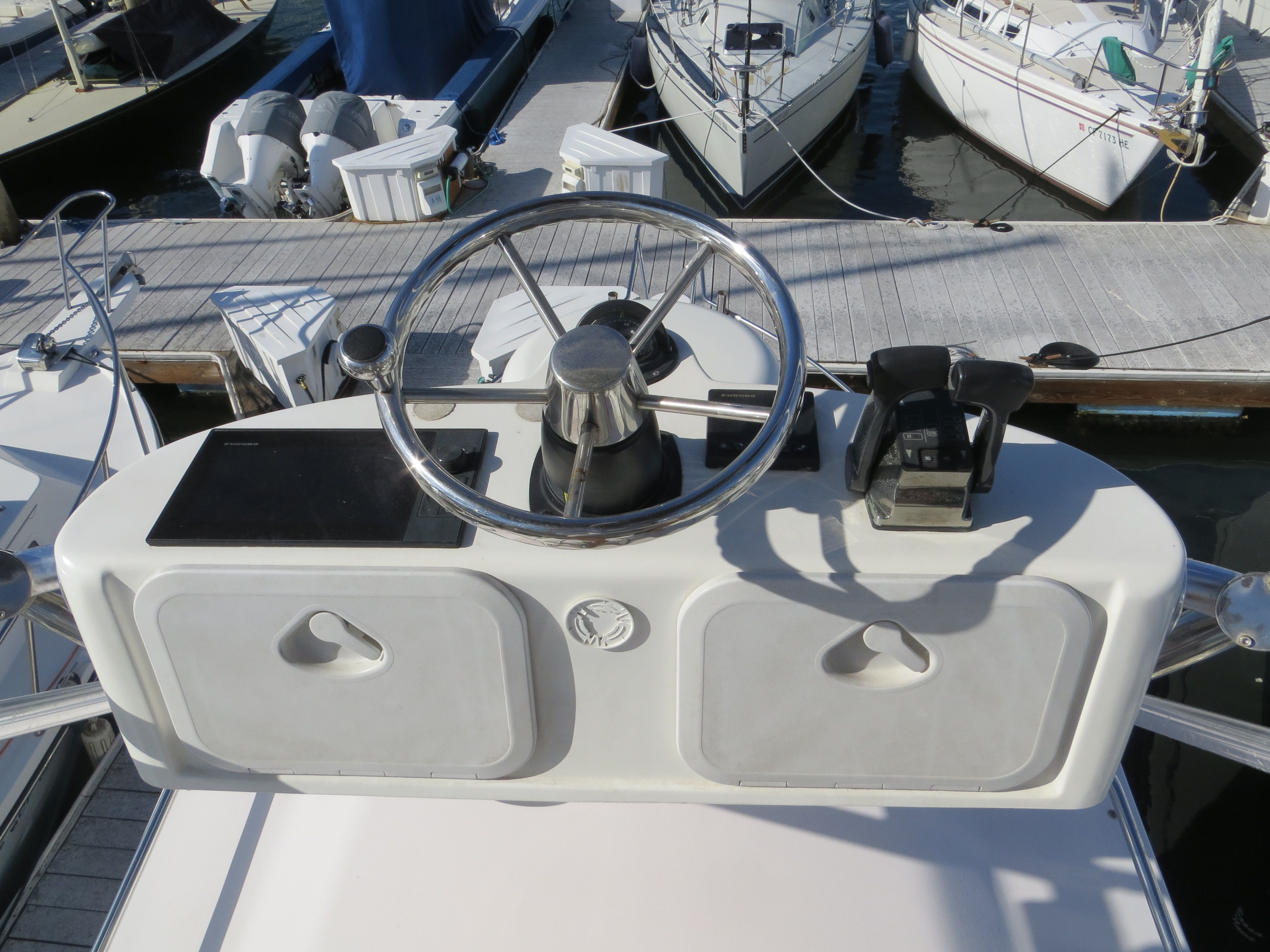 Helm of a 2007 Grady-White Sailfish 282 with steering wheel and throttle controls.