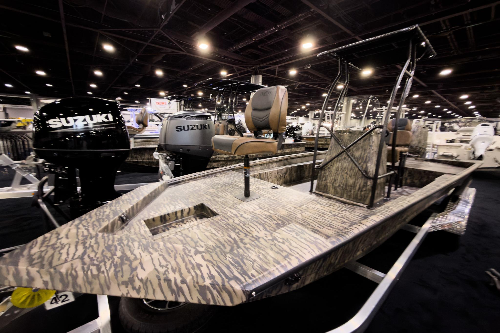 2026 Excel 216 Stalker Center Console boat with Suzuki engines on display indoors.