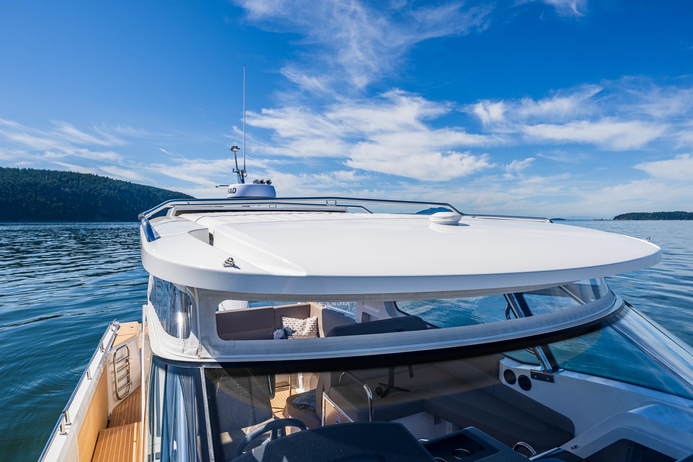 Nimbus W11 2025 yacht cruising on a serene lake under a clear blue sky.
