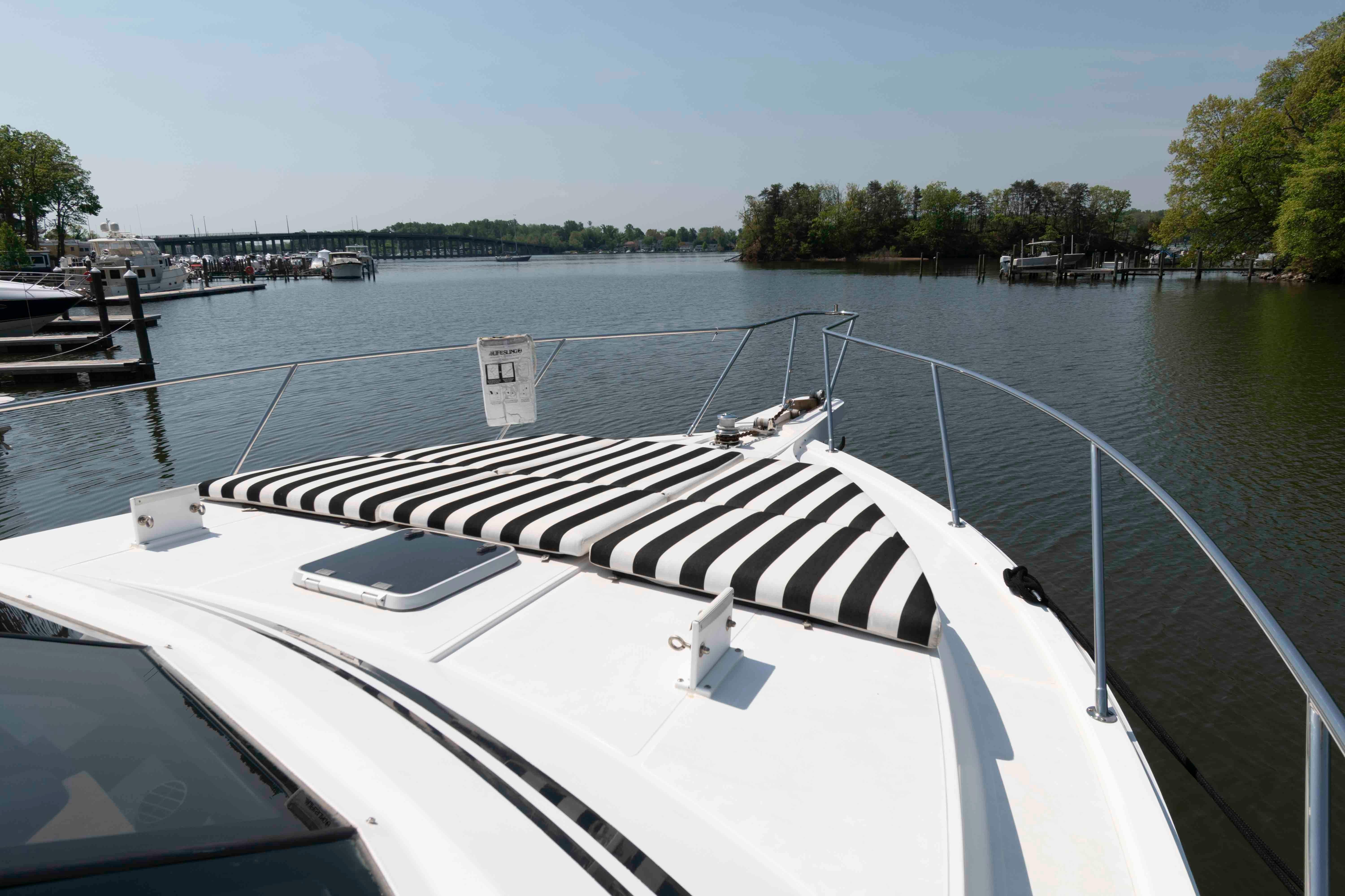 1999 West Bay 58 Sonship Pilothouse MY on calm water, striped sunbed on deck.