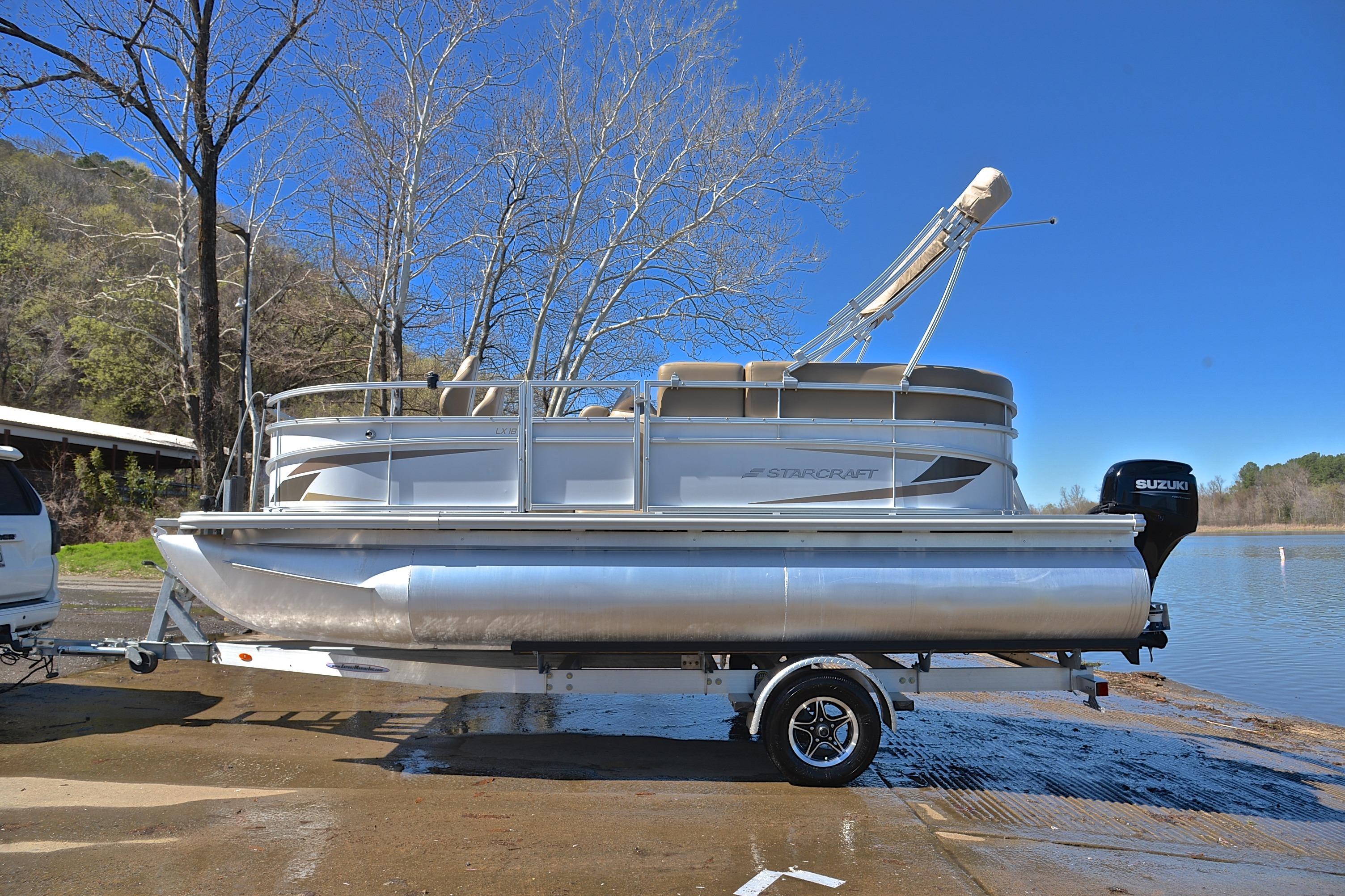 2023 Starcraft EX 18 F pontoon boat on trailer by a lake.