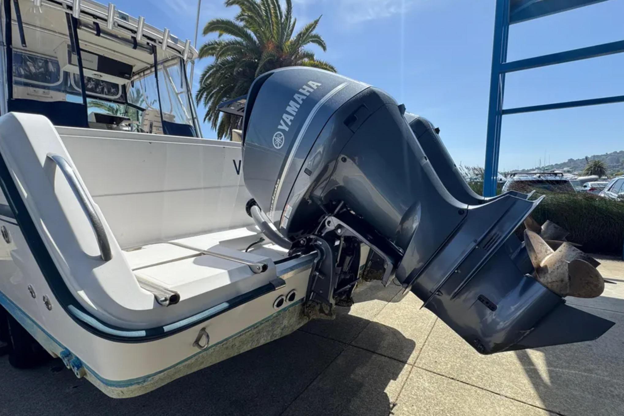 1990 Grady-White Marlin 280 boat with Yamaha outboard motor, docked under sunny skies.