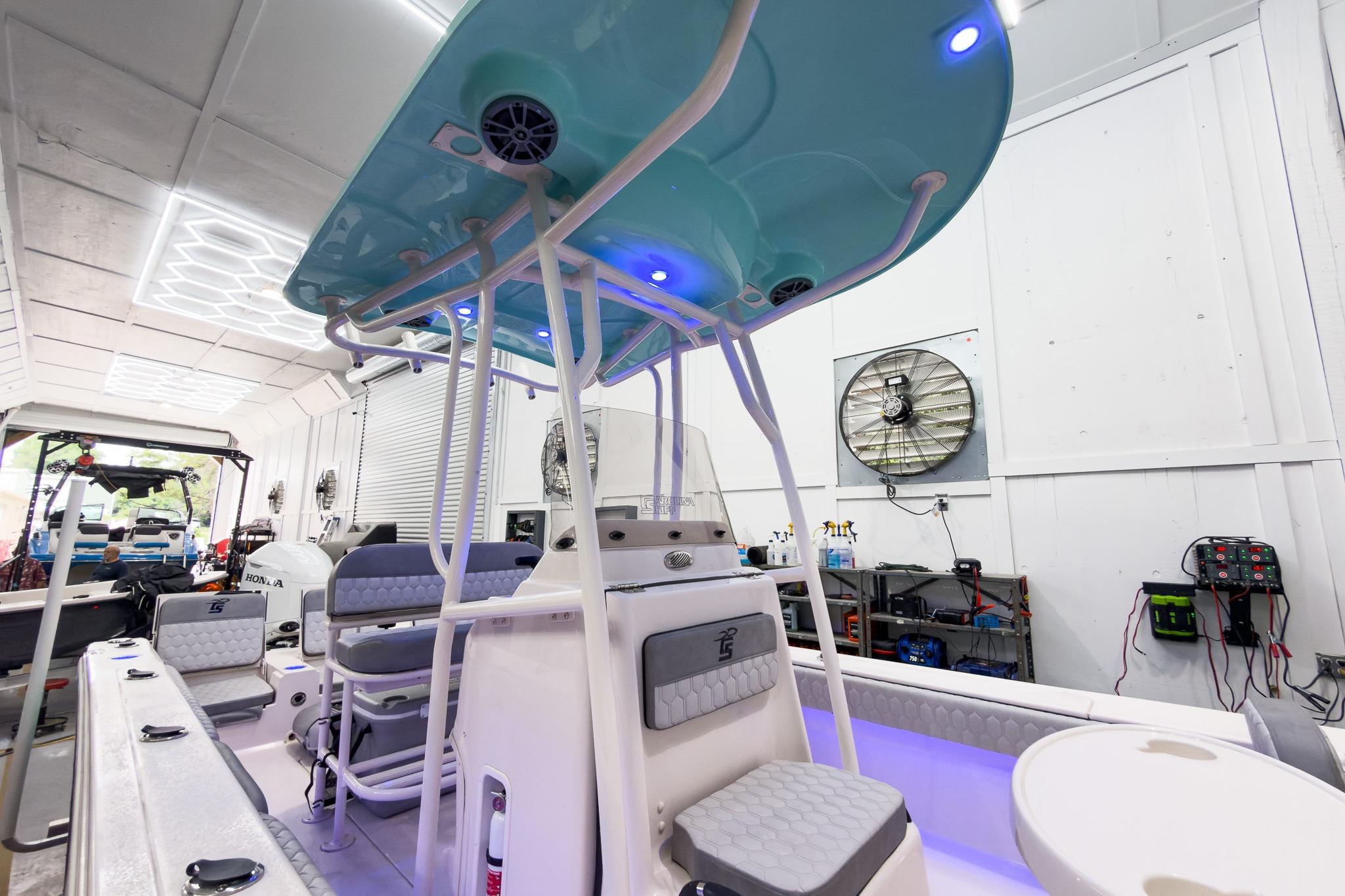 Interior view of 2026 Carolina Skiff 24 Ultra Elite boat in a workshop.