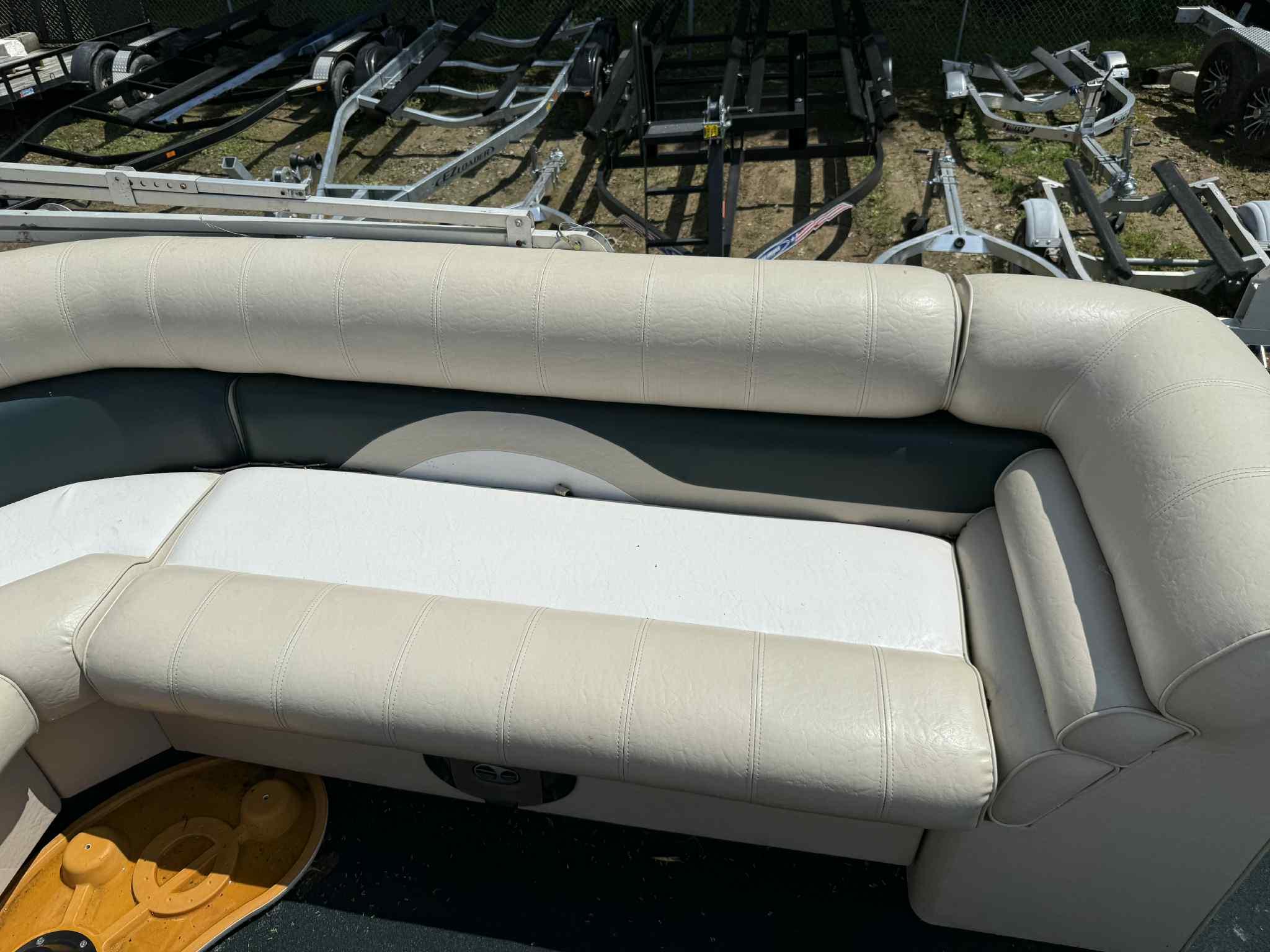 1999 Smoker Craft 8526 Pleasure Isle I/O boat interior with beige seating and trailer background.
