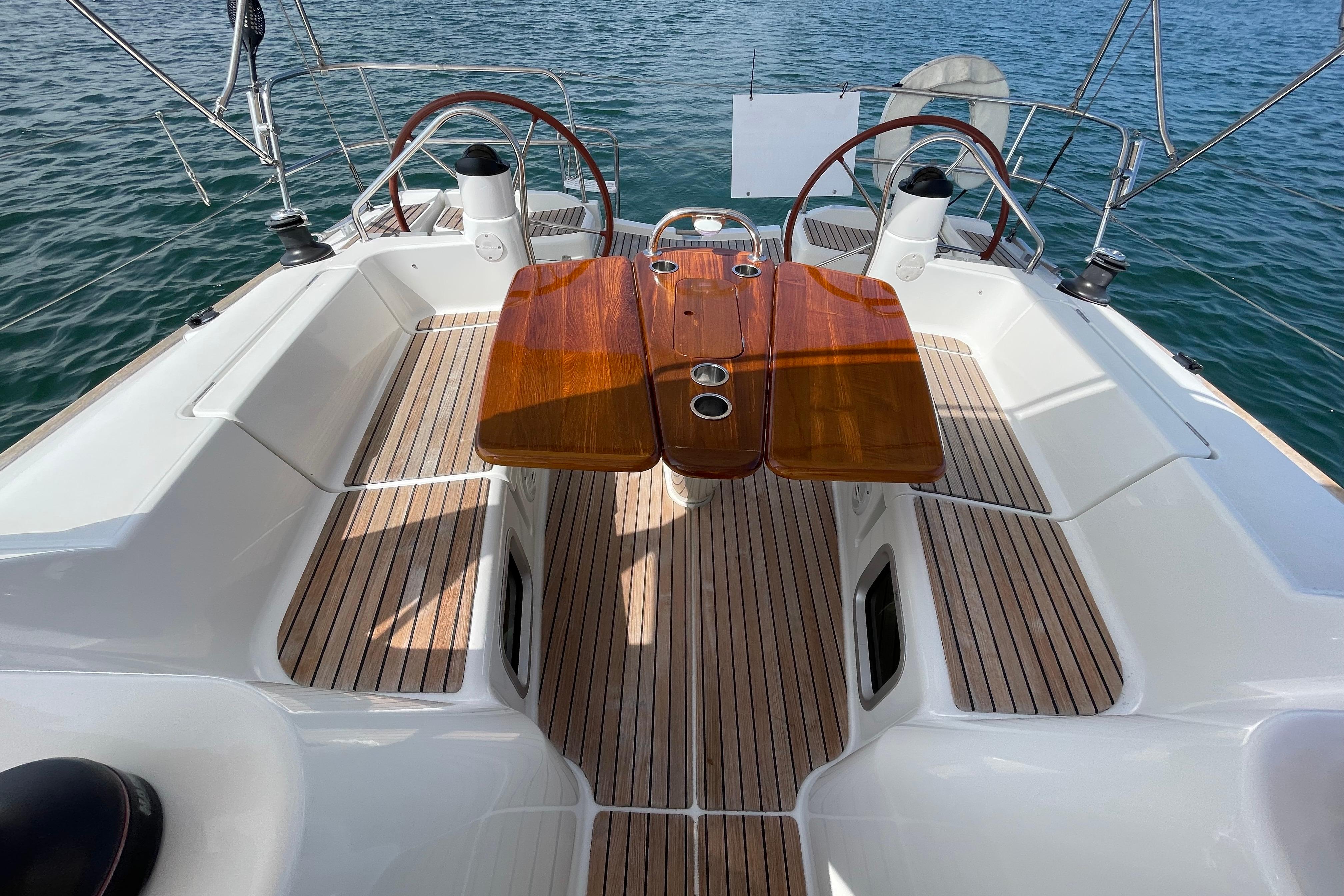 Cockpit of 2007 Jeanneau Sun Odyssey 39 DS with dual steering wheels and wooden table.