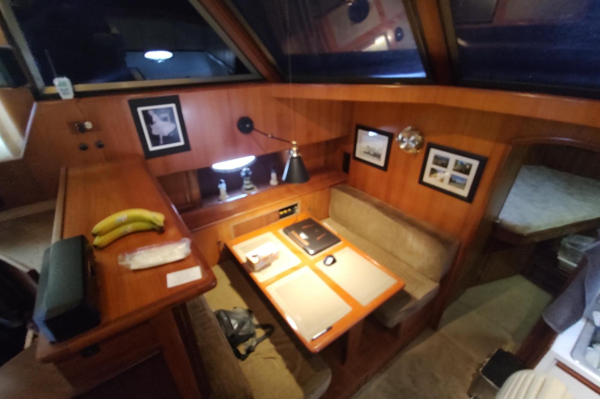 Interior of 1989 Hyatt Double Cabin Motoryacht with cozy dining area and wooden decor.