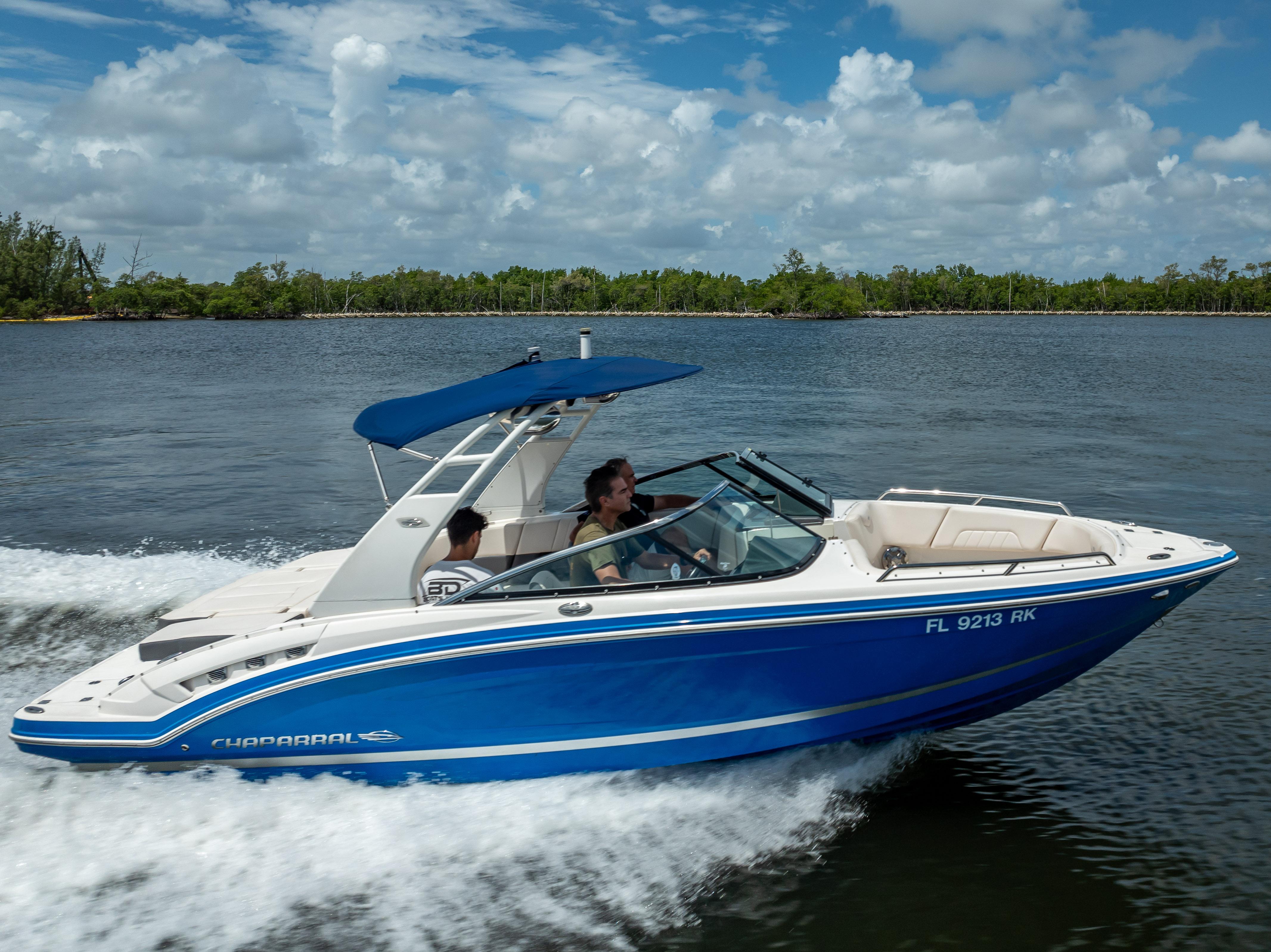 2017 Chaparral 227 SSX boat cruising on a lake under a blue sky.