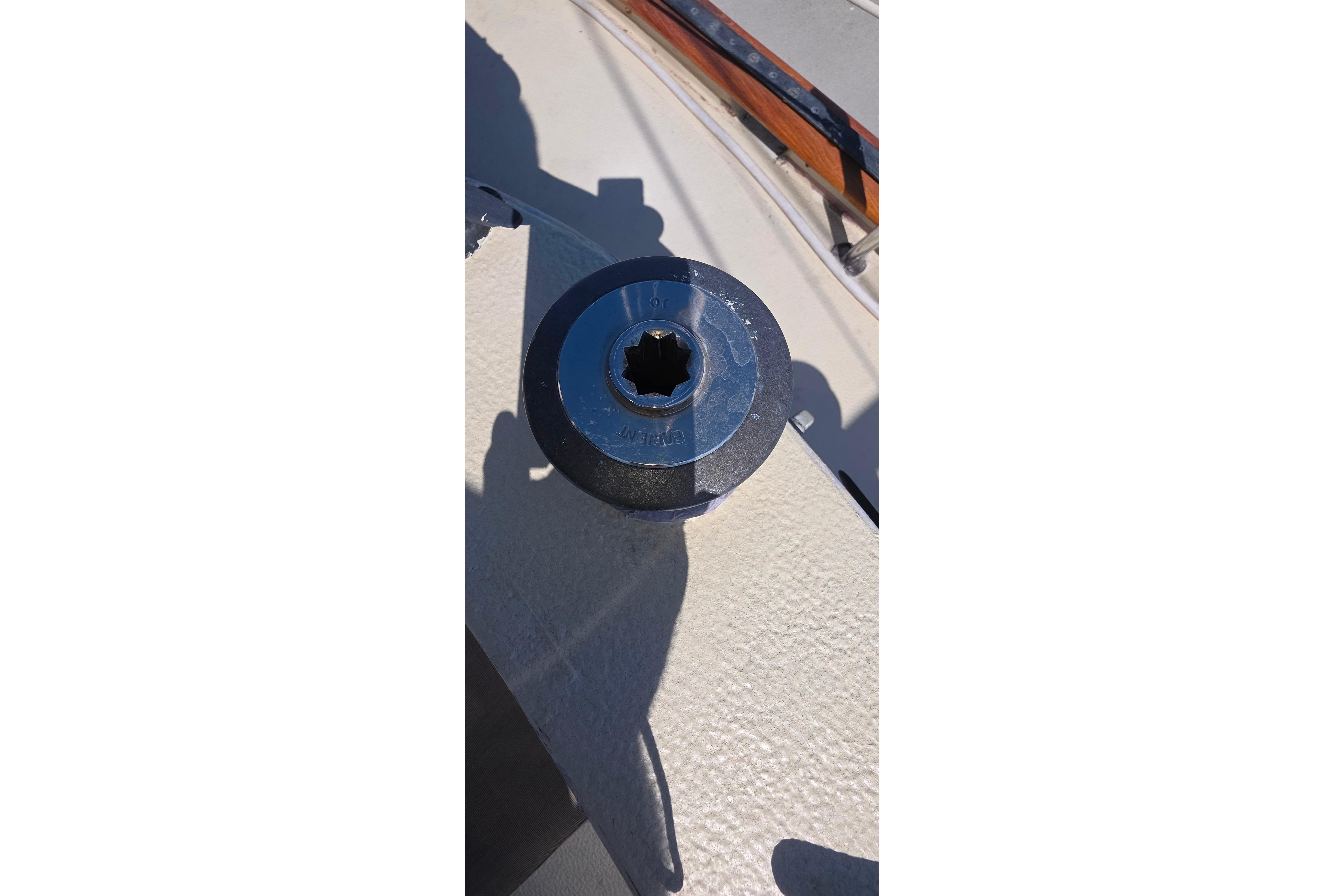 Winch on deck of 1978 Islander Freeport 41 sailboat, under sunlight.