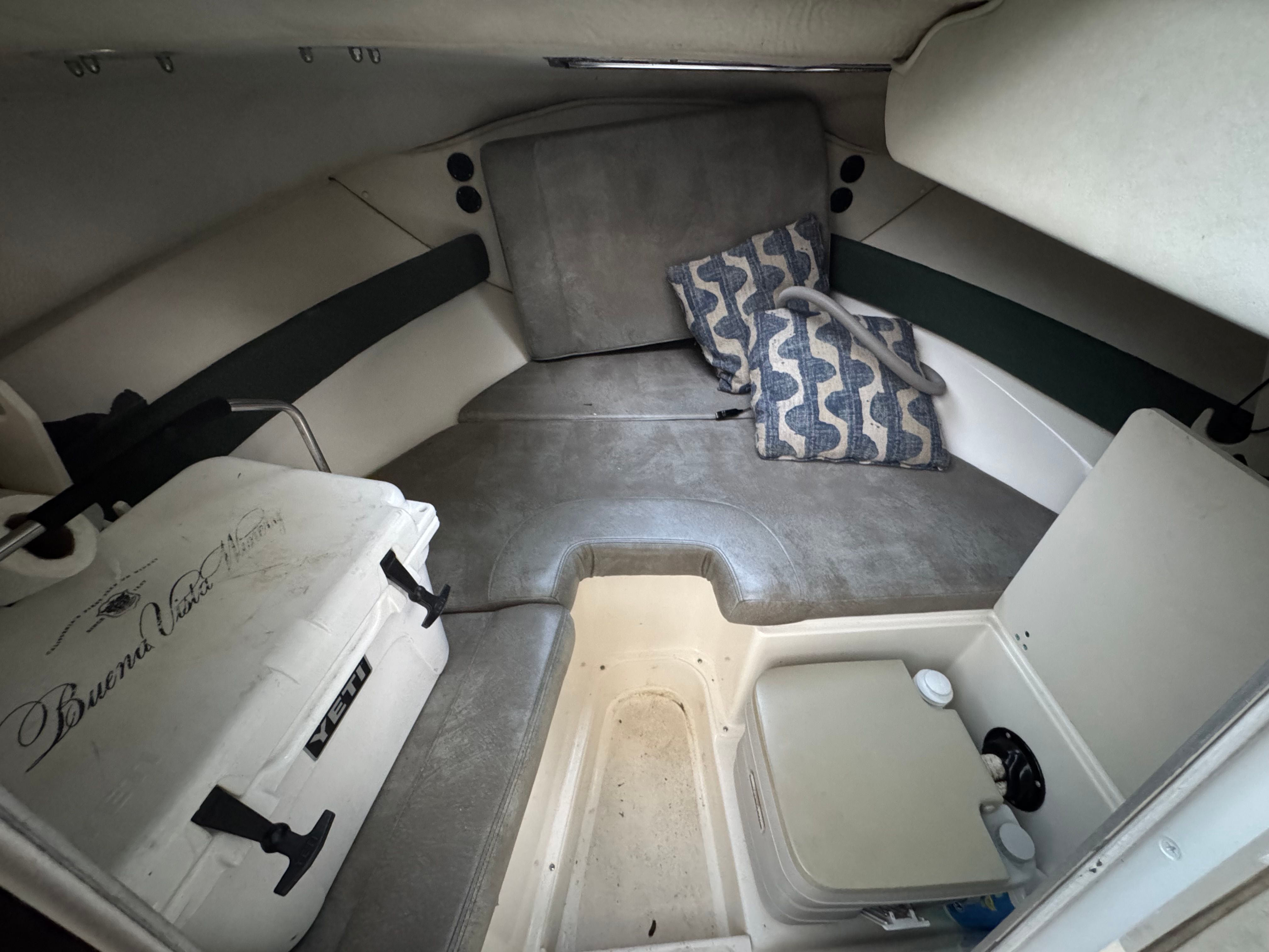Interior of a 2000 Boston Whaler Conquest with seating area and cooler.