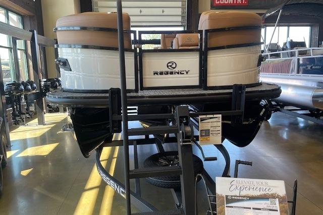 2026 Regency 230 DL pontoon boat displayed indoors, showcasing sleek design and luxury seating.