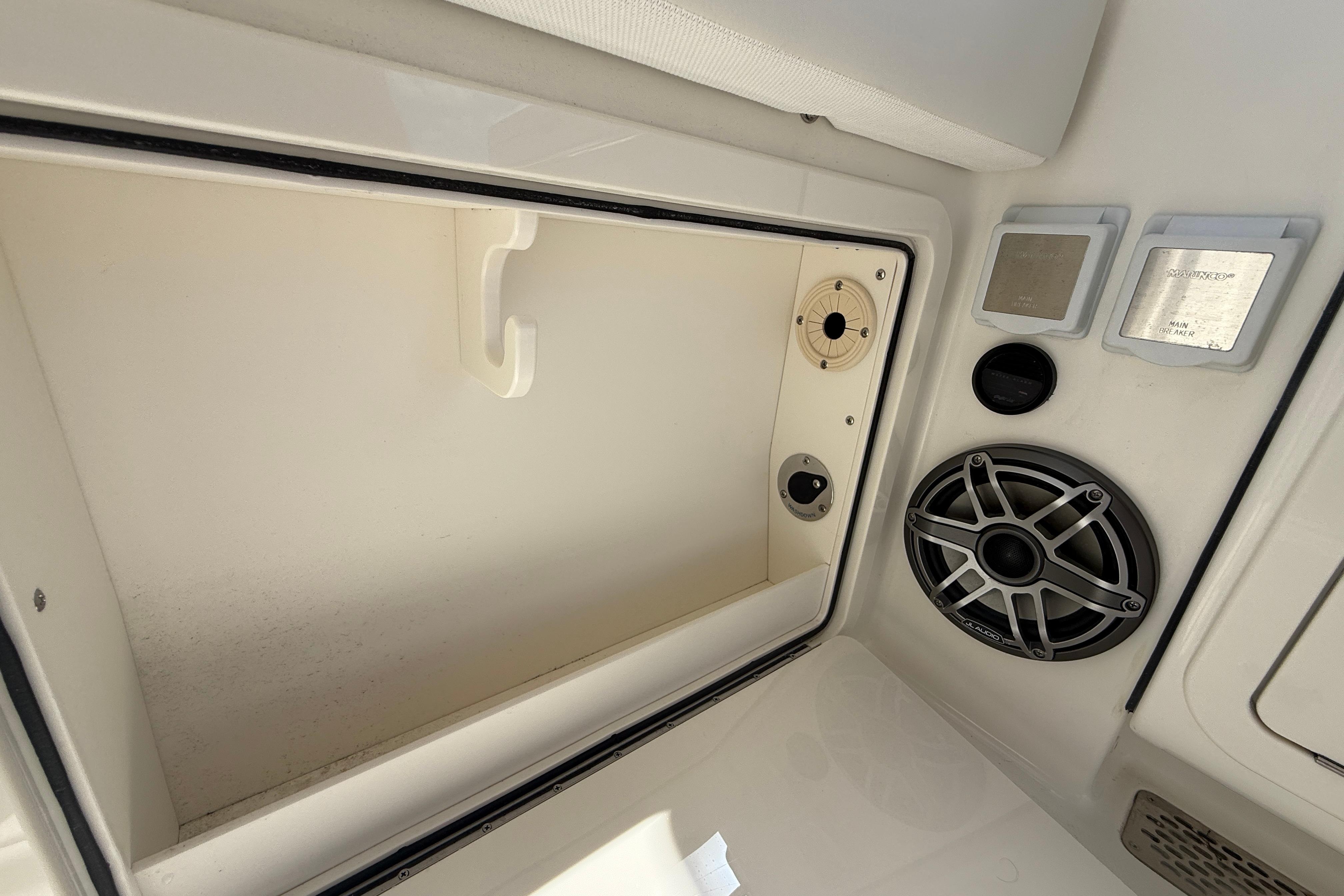 Interior view of 2026 World Cat 400 DC-X Island boat, featuring storage compartment and speaker system.