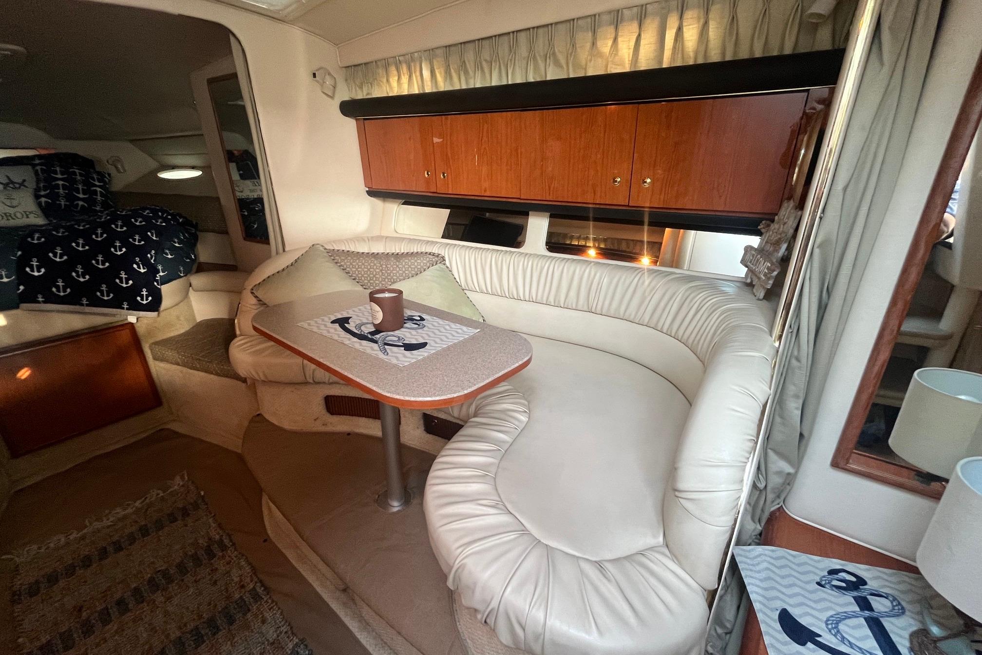 Interior of 2001 Sea Ray 340 Sundancer with cozy seating and nautical decor.
