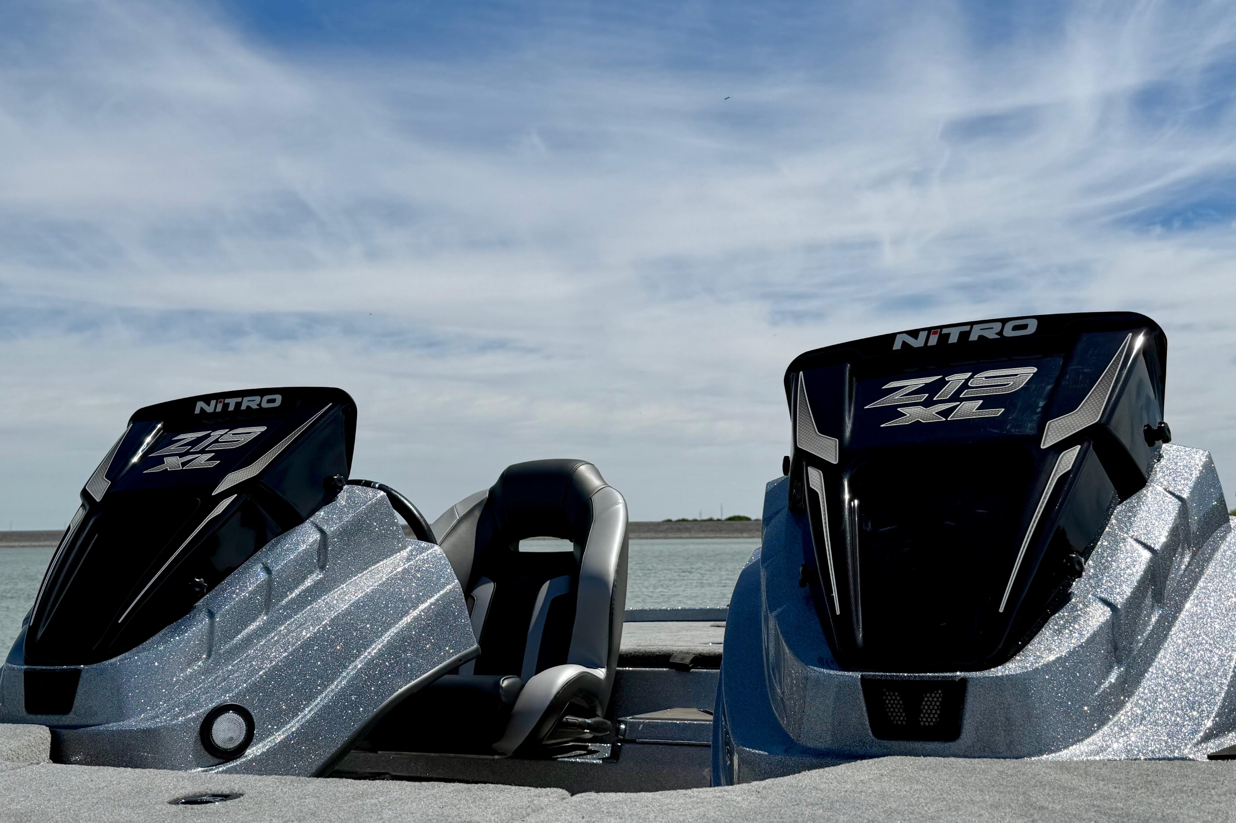 2026 Nitro Z19 XL boat engines against a serene lake backdrop under a blue sky.