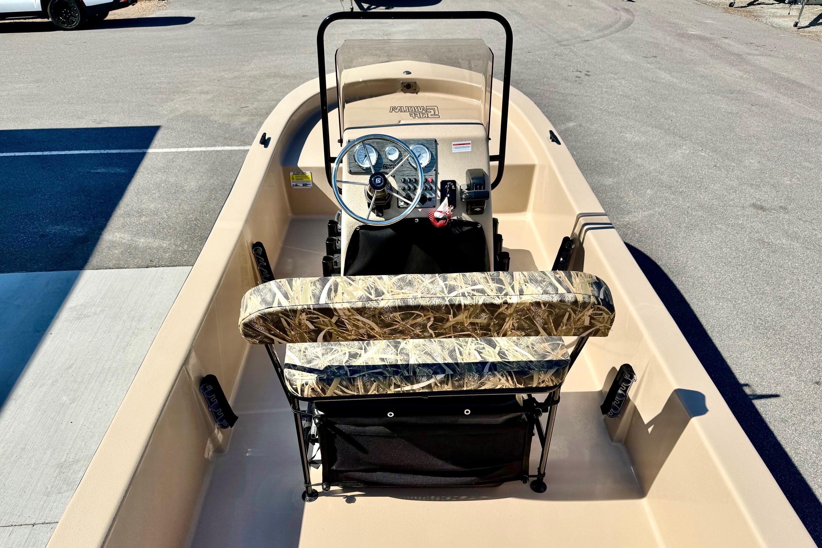 2026 Carolina Skiff E18 JVX CC boat interior with camo seating and steering console.