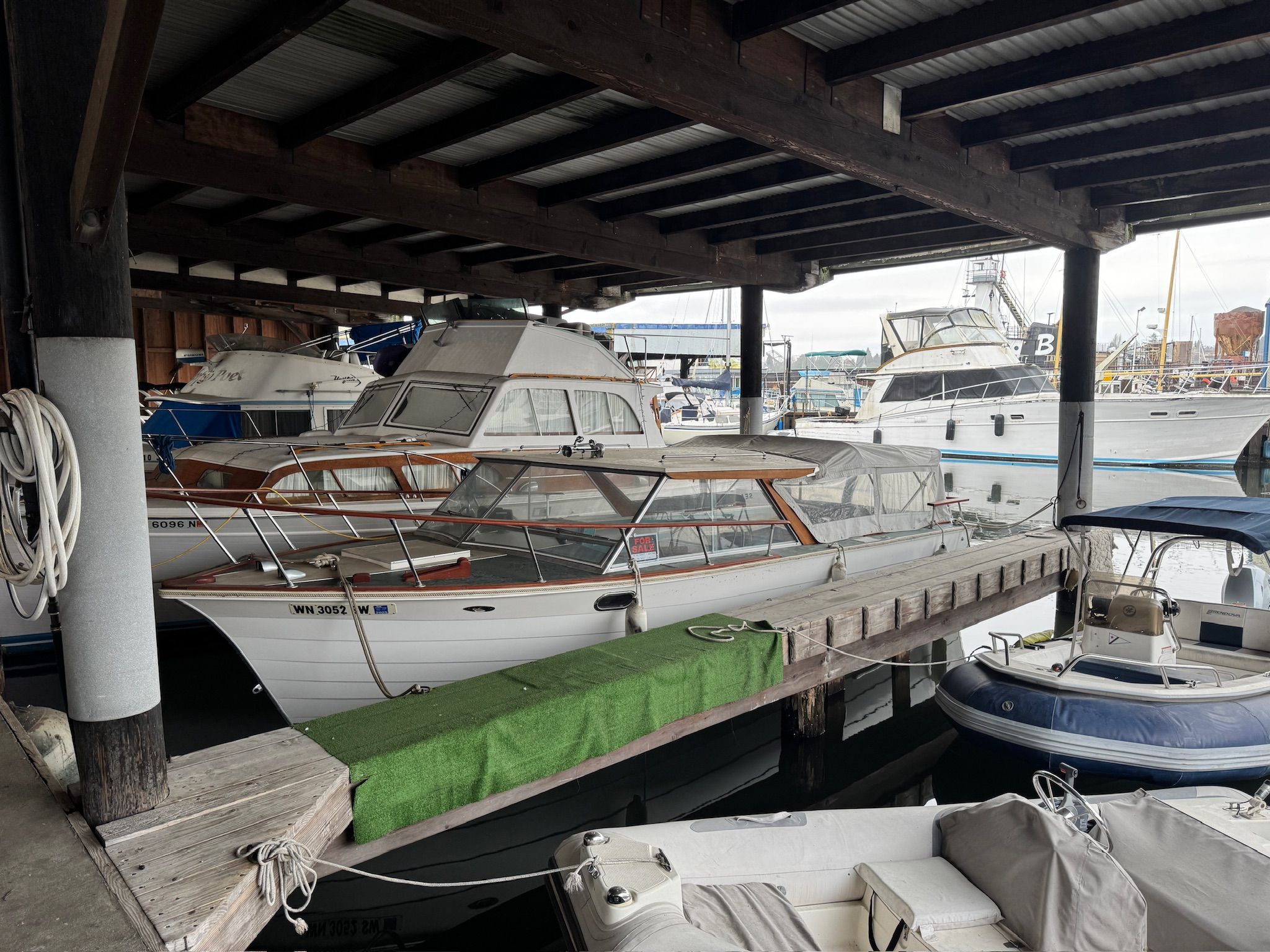A 1972 Skiff Craft Hardtop is docked in a covered marina area. Other boats are visible in the background.