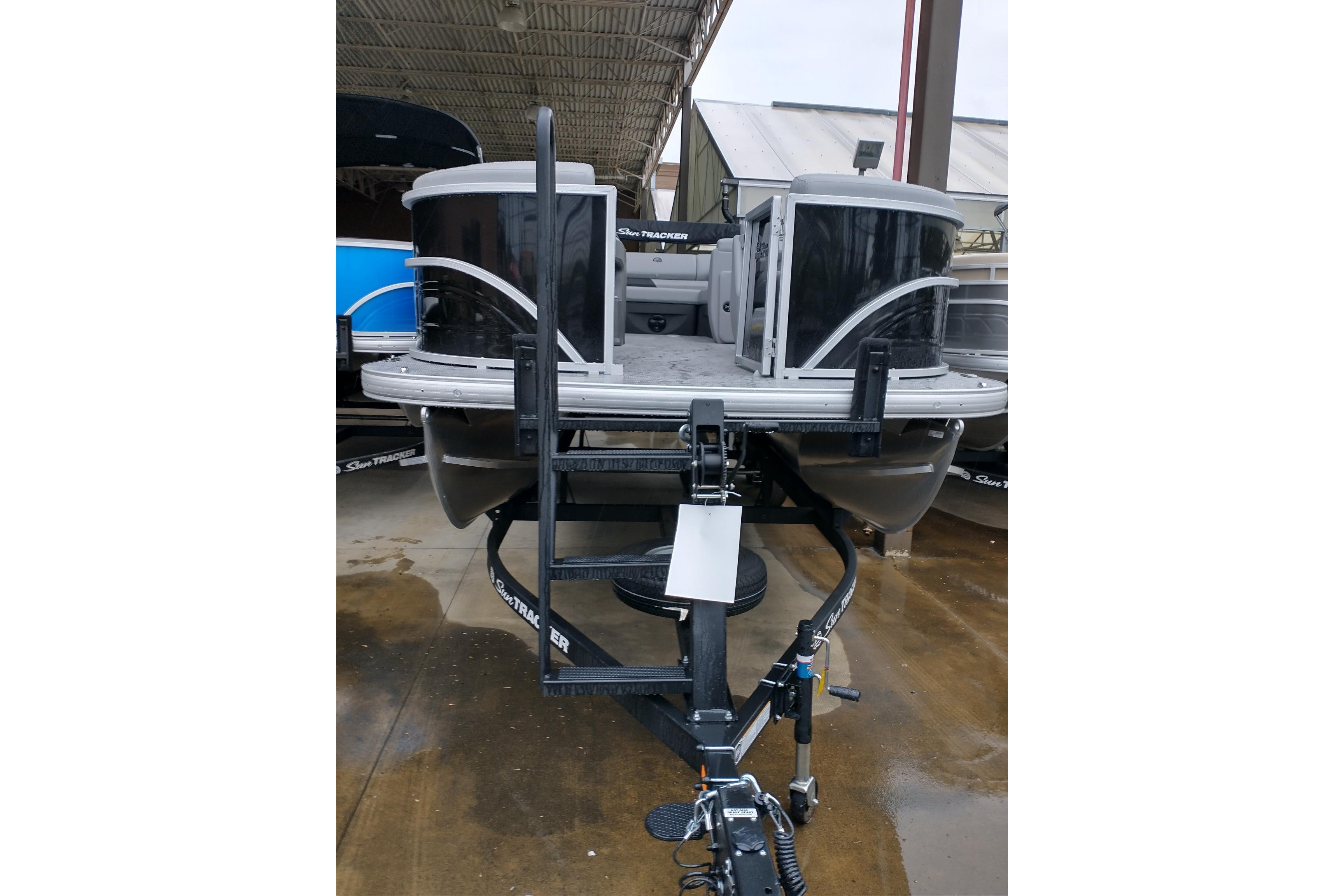 2026 Sun Tracker Party Barge 20 DLX pontoon boat on trailer in storage facility.