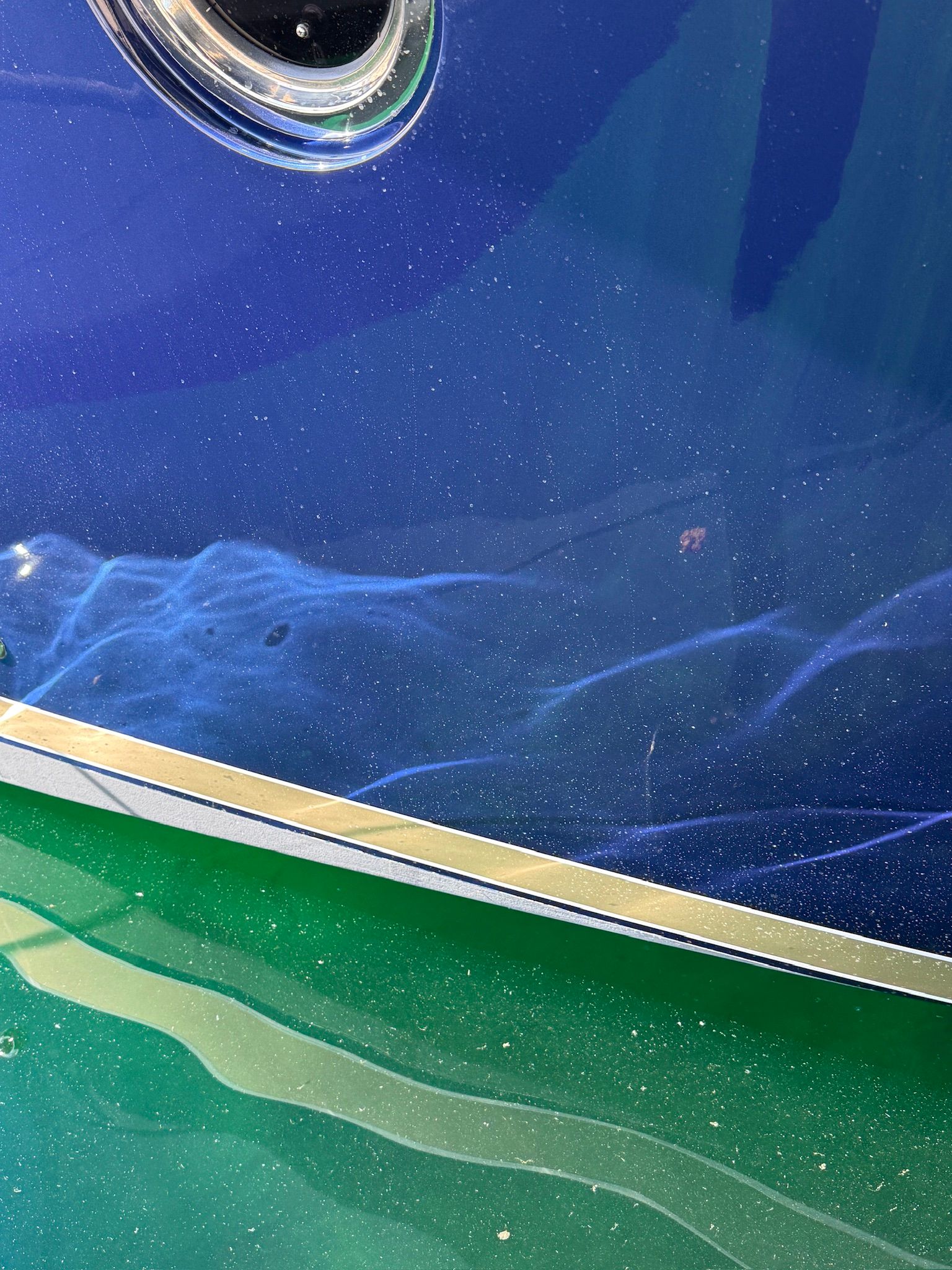 Close-up of the blue hull of a 2017 Tiara Yachts C44 Coupe in the water.