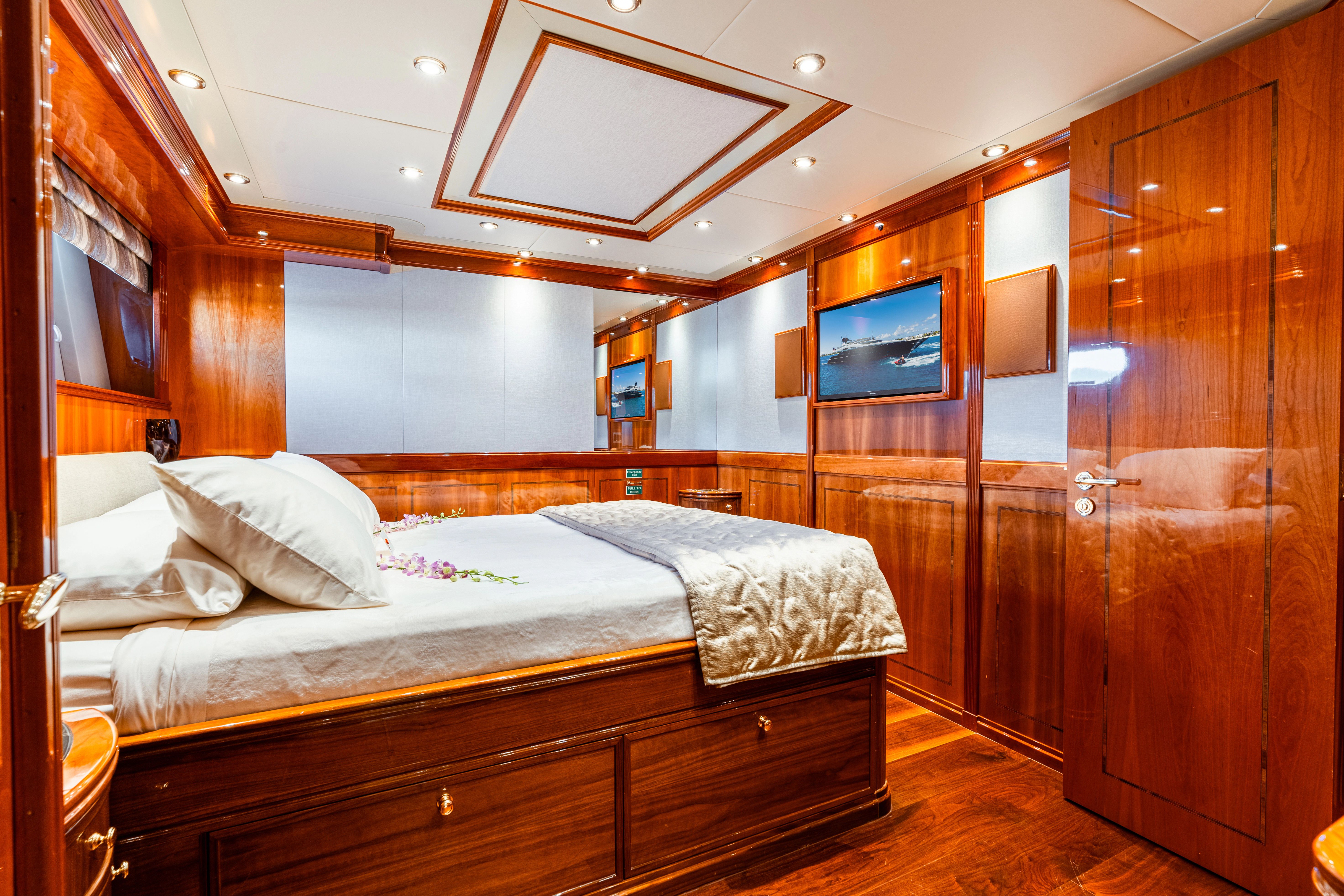 Luxurious cabin with wooden walls, a large bed, and a wall-mounted TV.