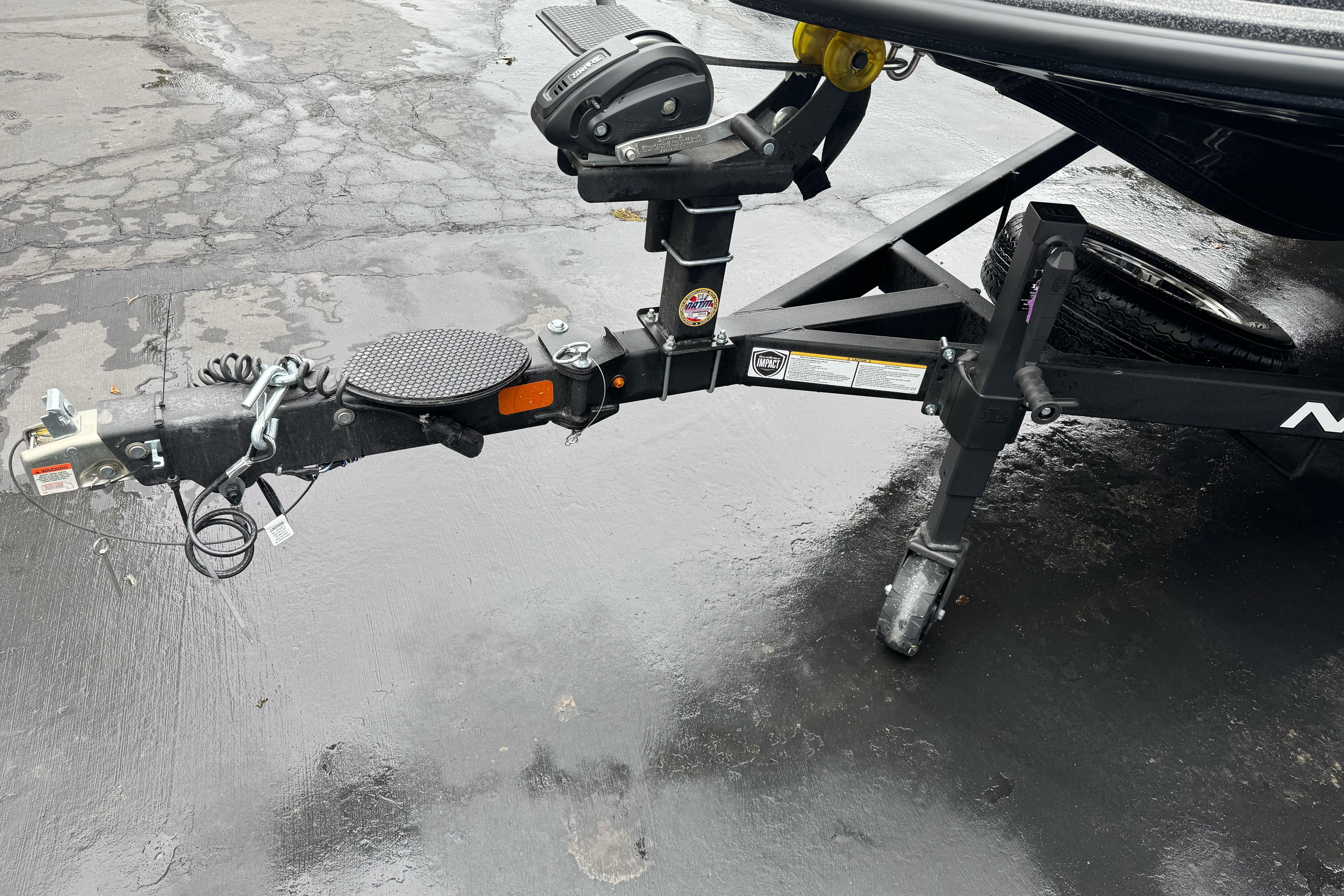 Trailer hitch of a 2026 Nitro Z20 XL Pro boat on wet pavement.