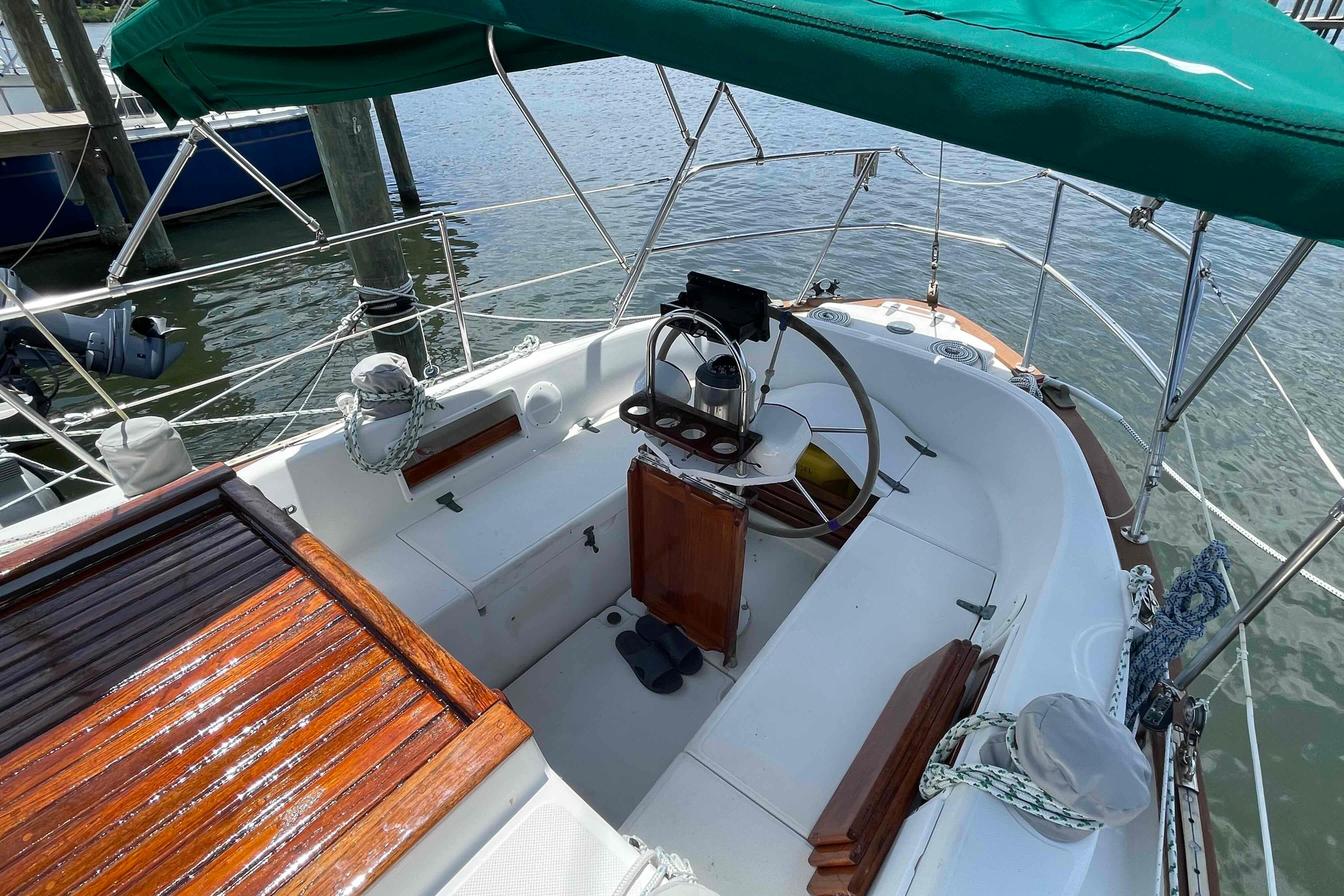 1987 Pacific Seacraft 34 sailboat cockpit with wooden accents and green canopy.