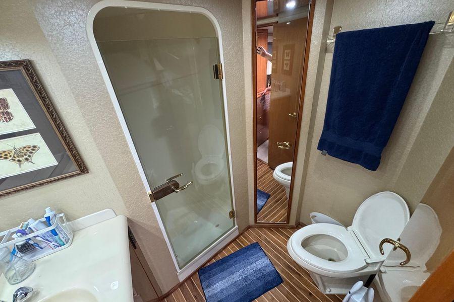 Bathroom interior of 2002 Viking 61 Enclosed Bridge yacht with shower and toilet.