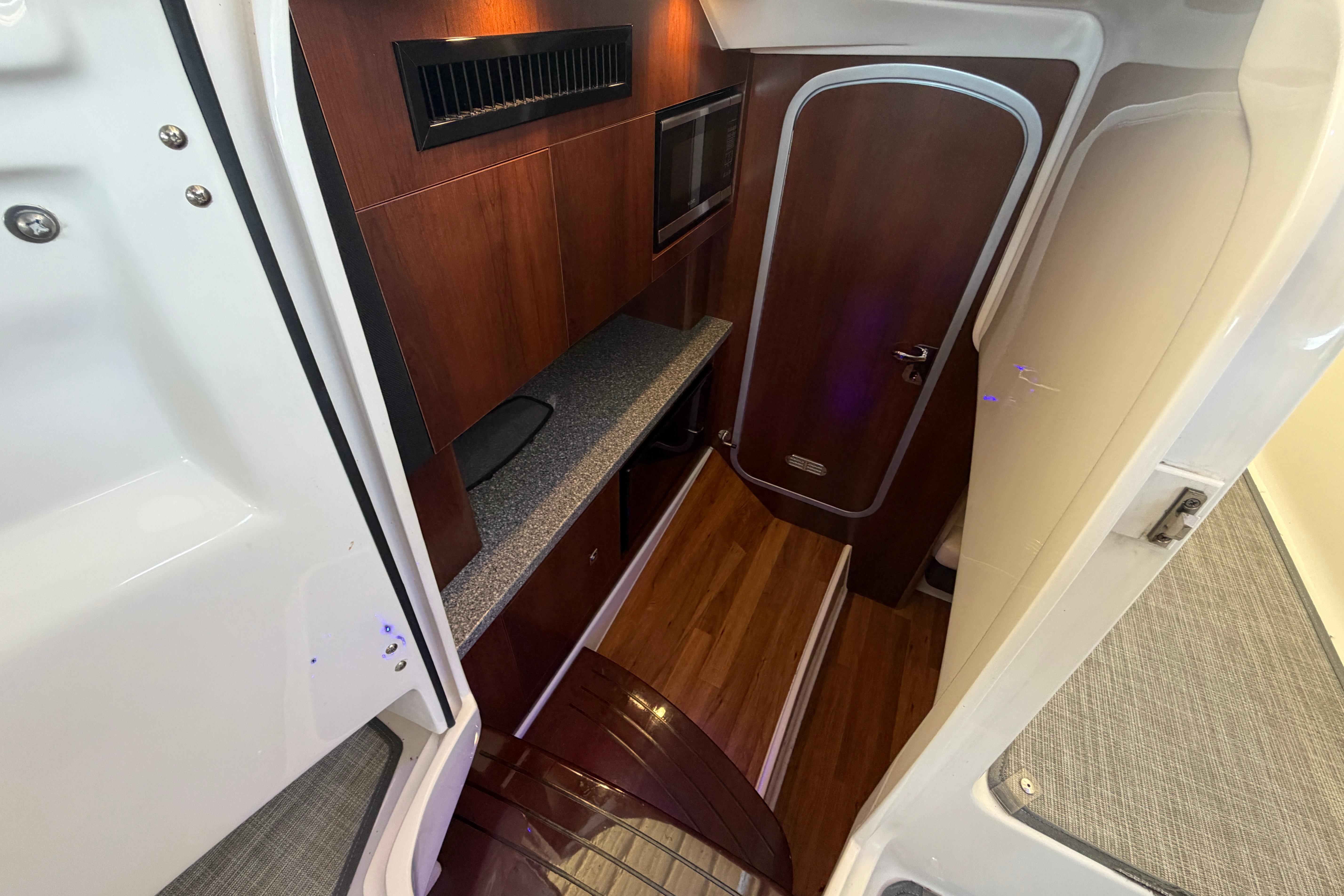 Interior of 2018 Chaparral 347 SSX boat with wood flooring and modern cabinetry.