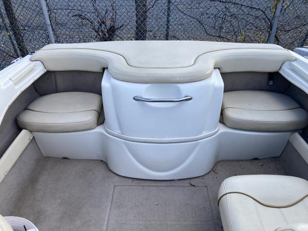2001 Sea Ray 180 Bow Rider interior with beige seating and storage compartment.