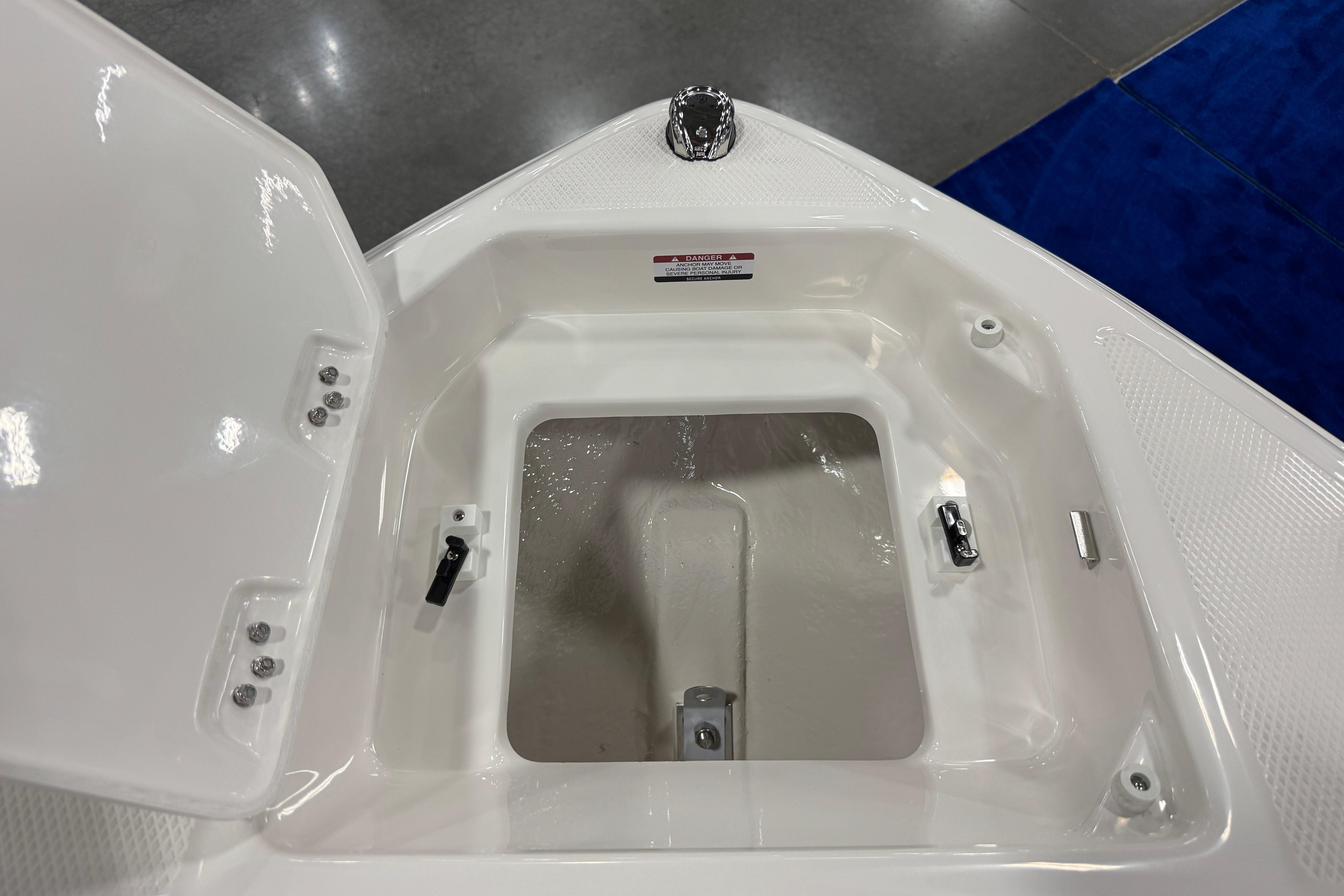 Open storage compartment on 2026 Chaparral 23 SSi boat, featuring sleek white interior design.