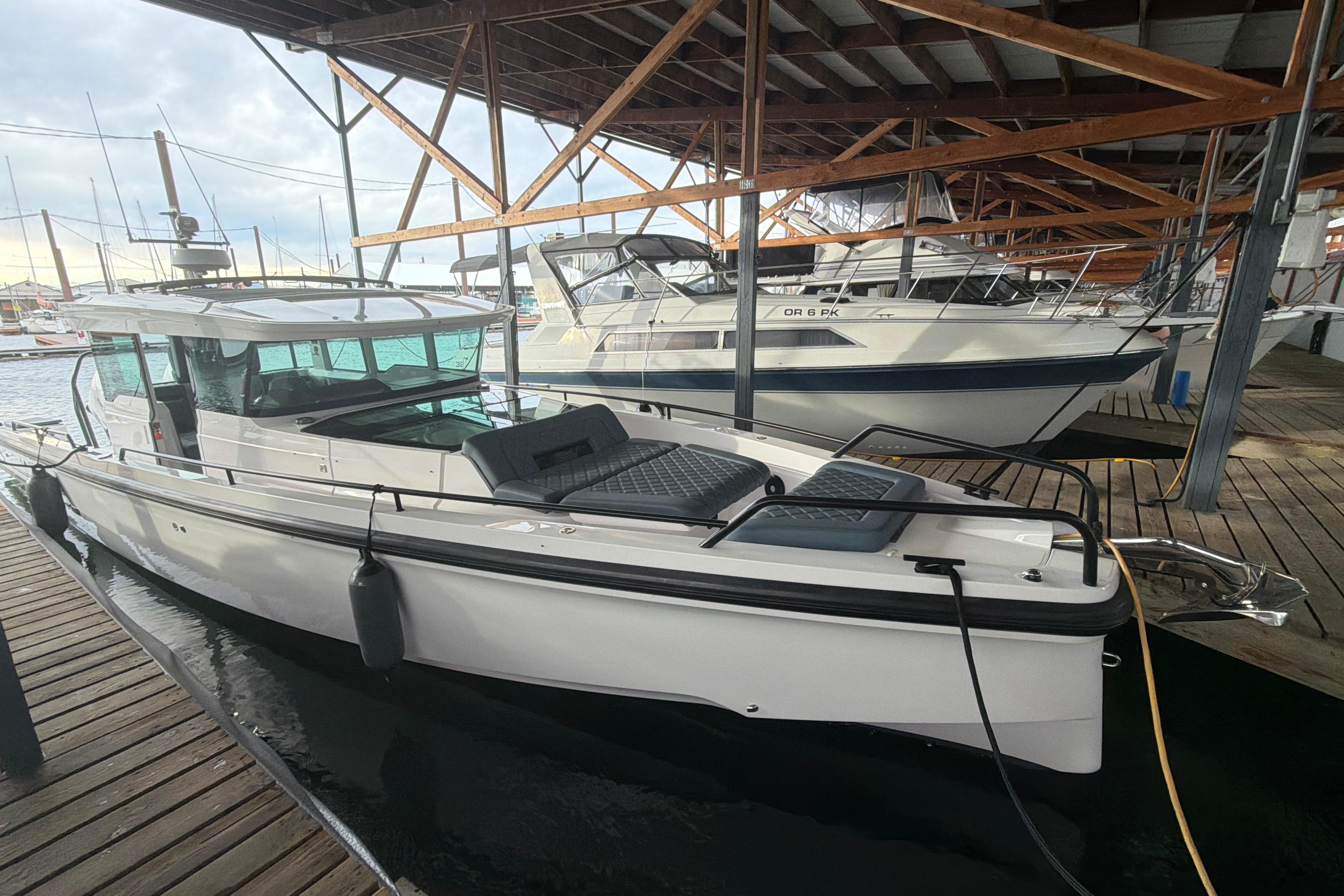 2022 Axopar Brabus 37 XC Cross Cabin docked in a marina under a wooden roof.