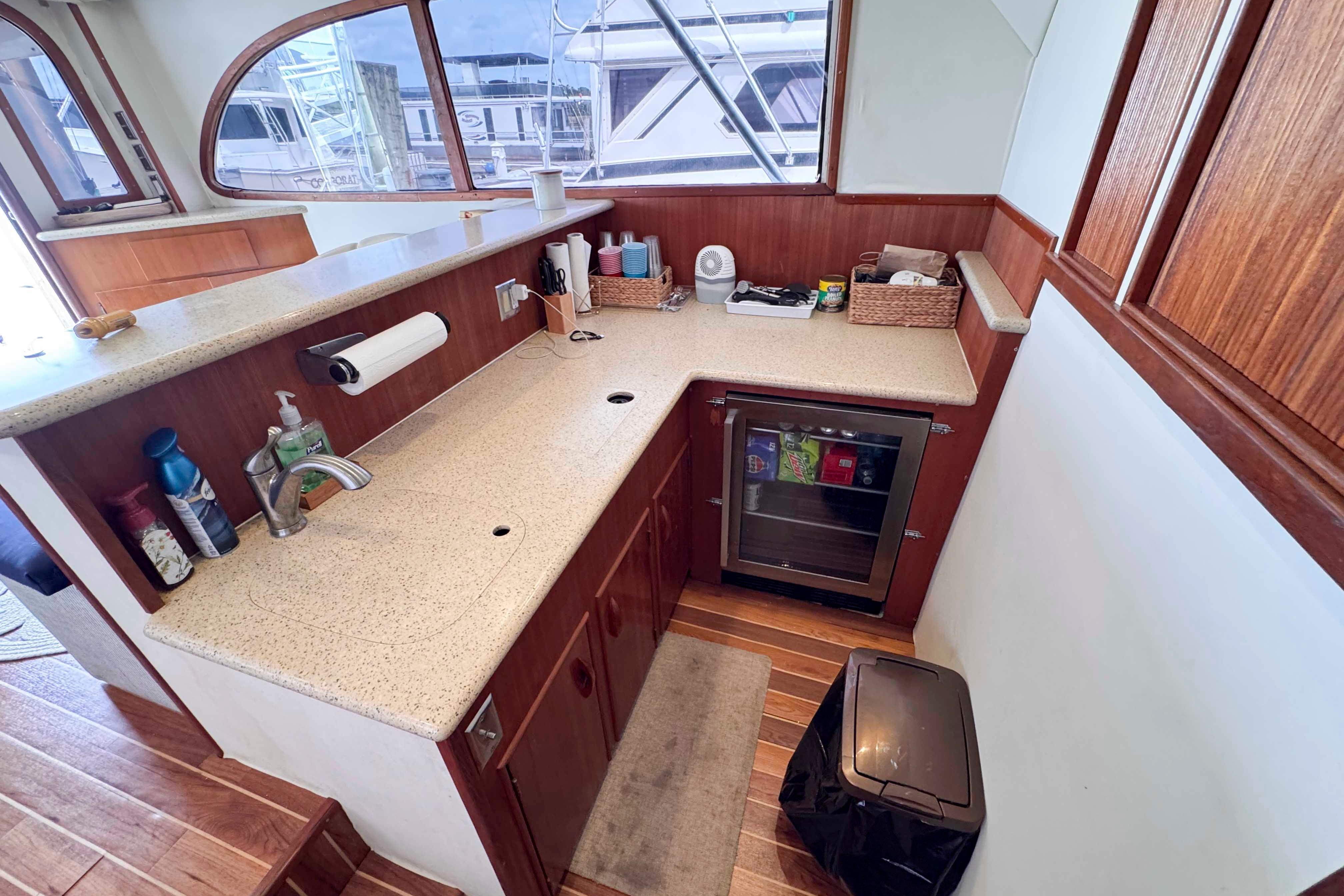 Galley kitchen in 1989 Buddy Davis 47 yacht with wood cabinetry and mini fridge.