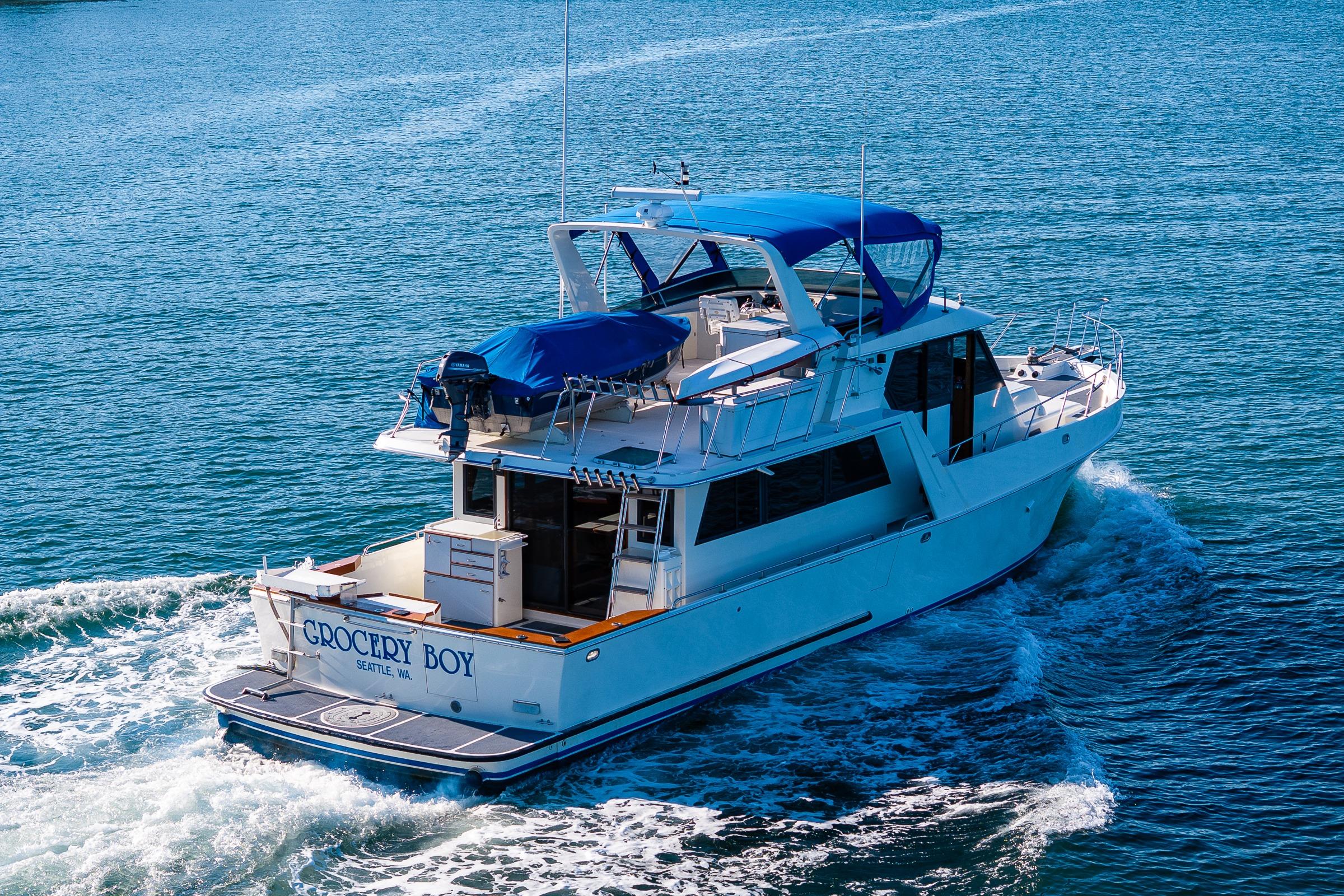 A 1989 Nordic 52 yacht cruising on blue waters with a blue canopy.
