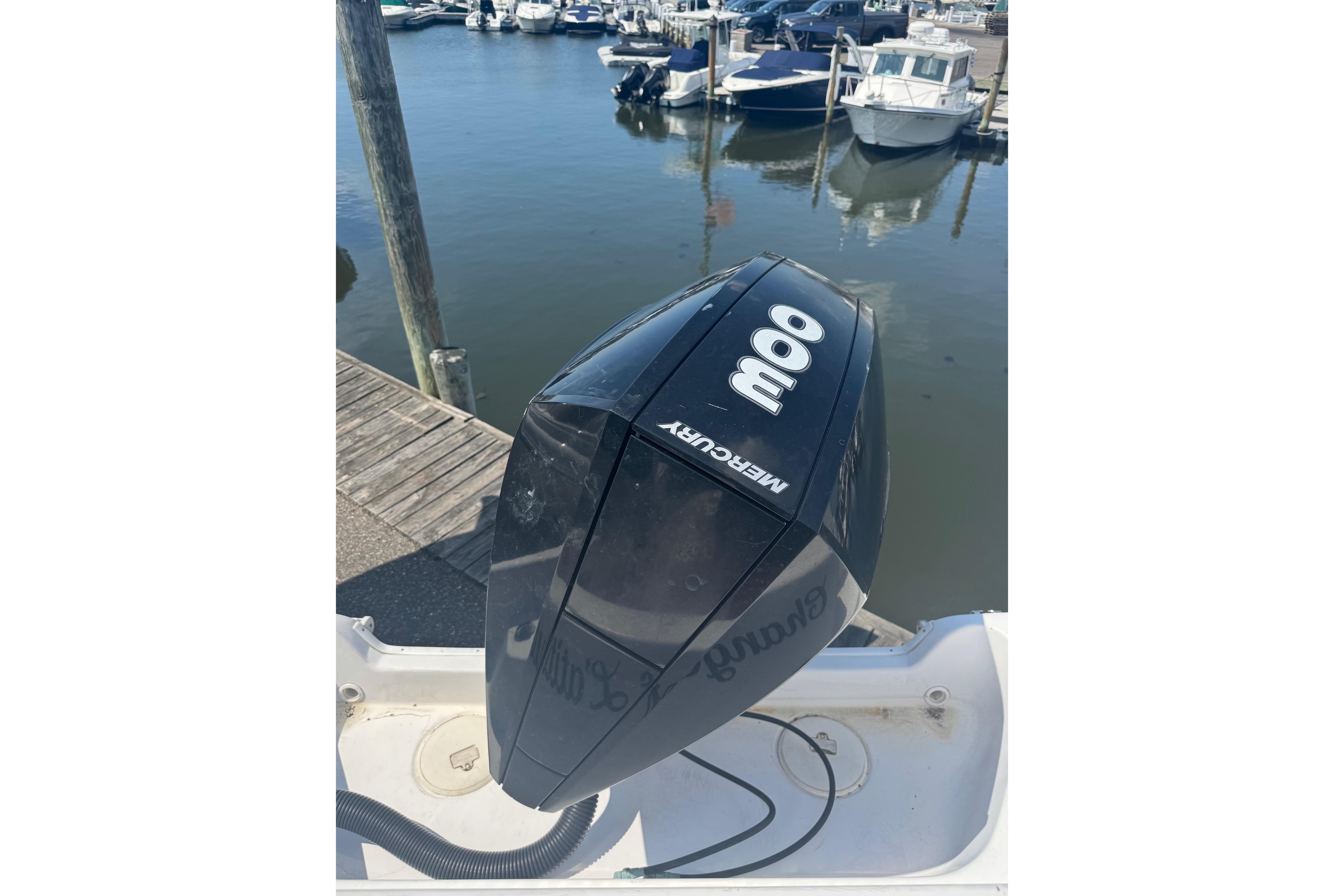 Outboard motor on a 2002 Pro-Line 23 Sport boat docked at a marina.