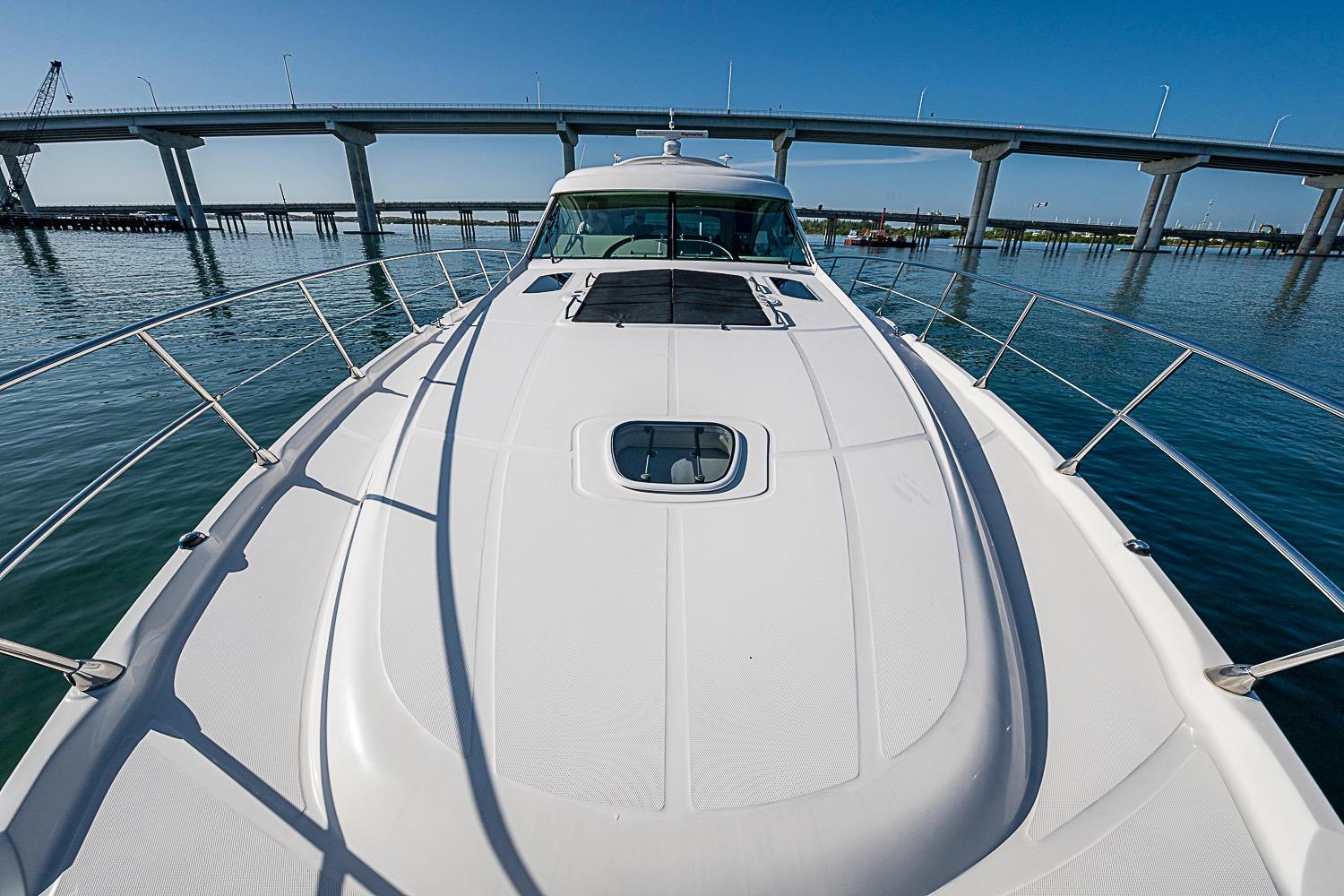 2008 Sea Ray 60 Sundancer yacht cruising under a bridge on a sunny day.