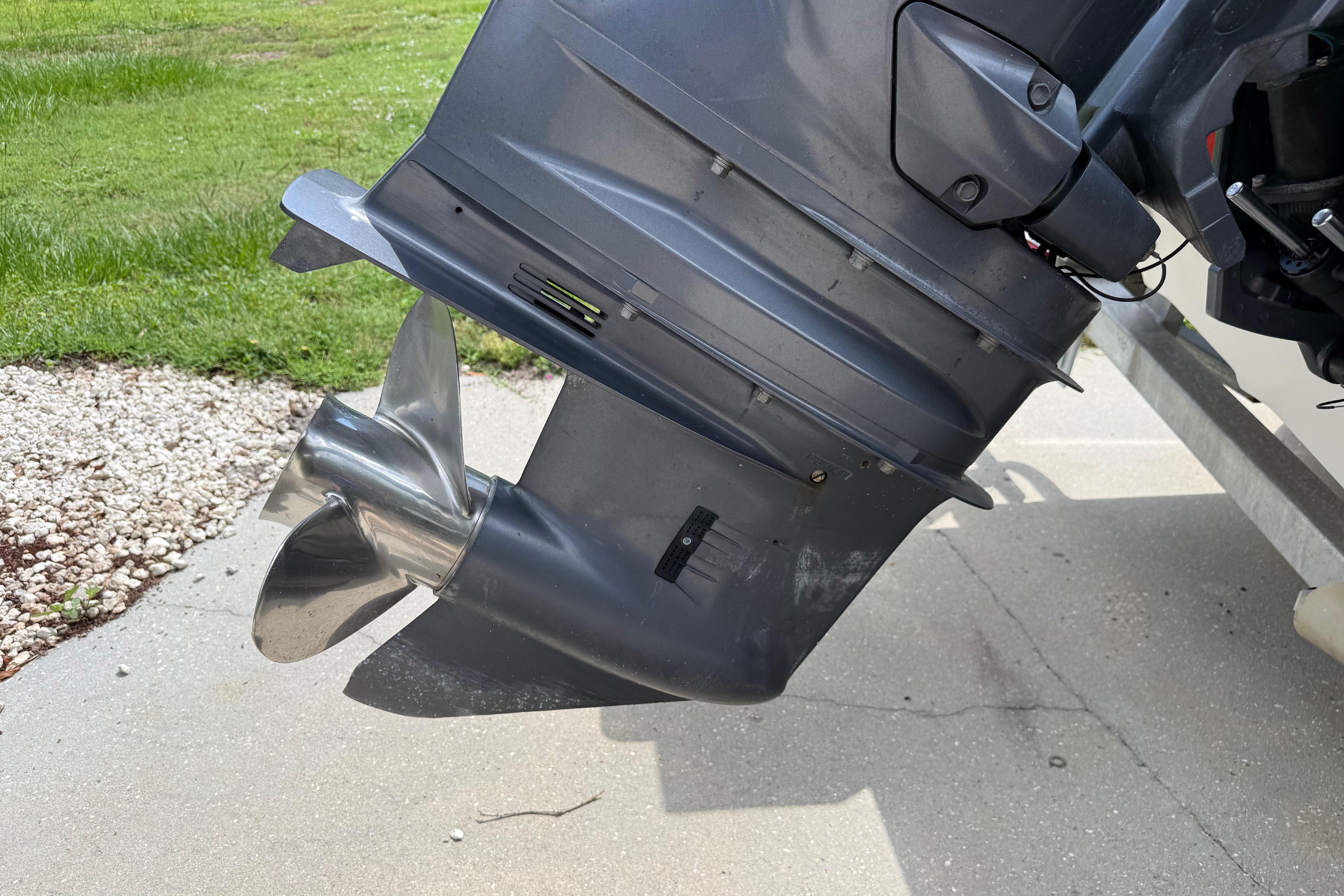 Outboard motor of a 2012 Clearwater 2000 Center Console boat on a concrete surface.