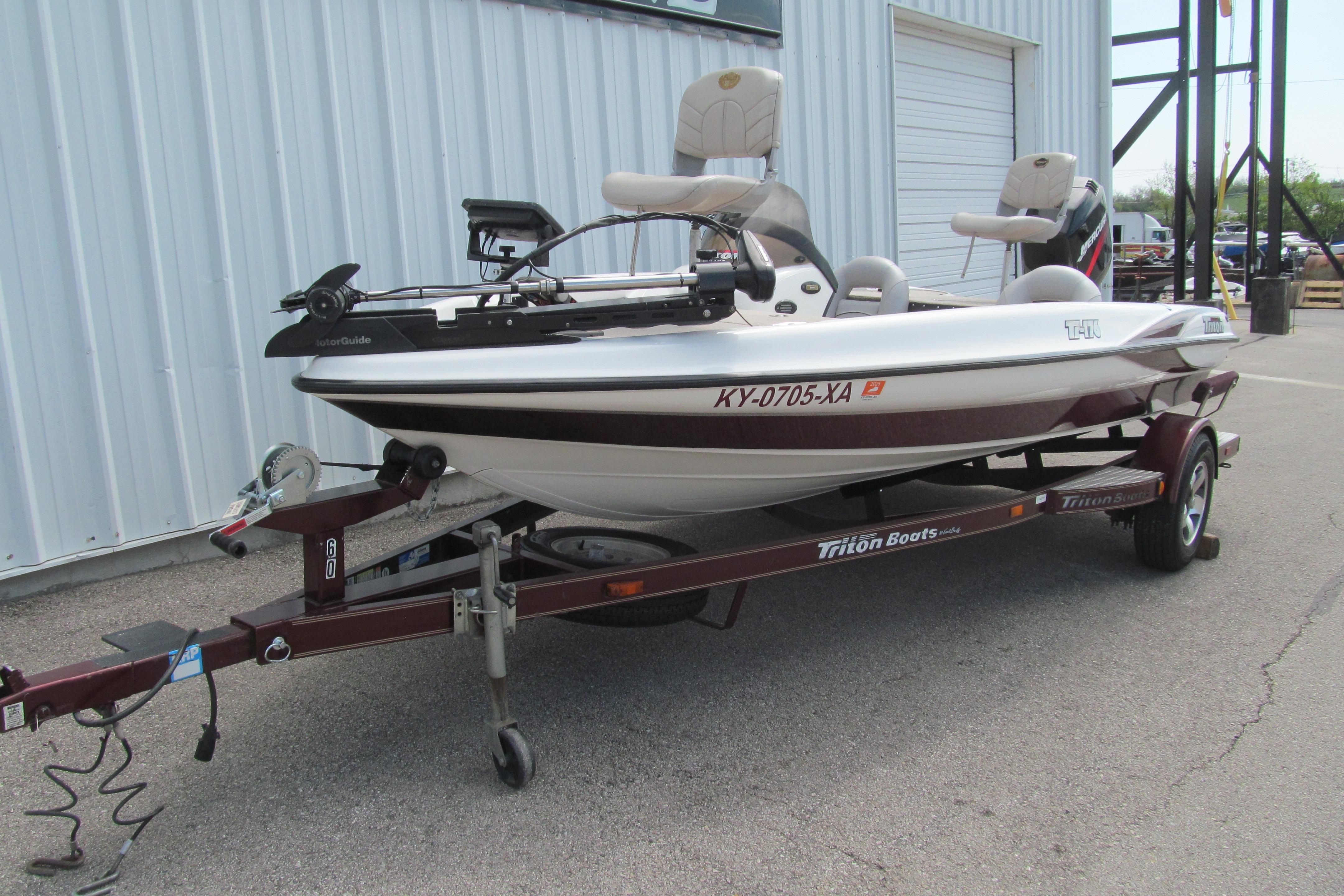 2002 Triton Tr-176 SC fishing boat on trailer, parked near a metal building.