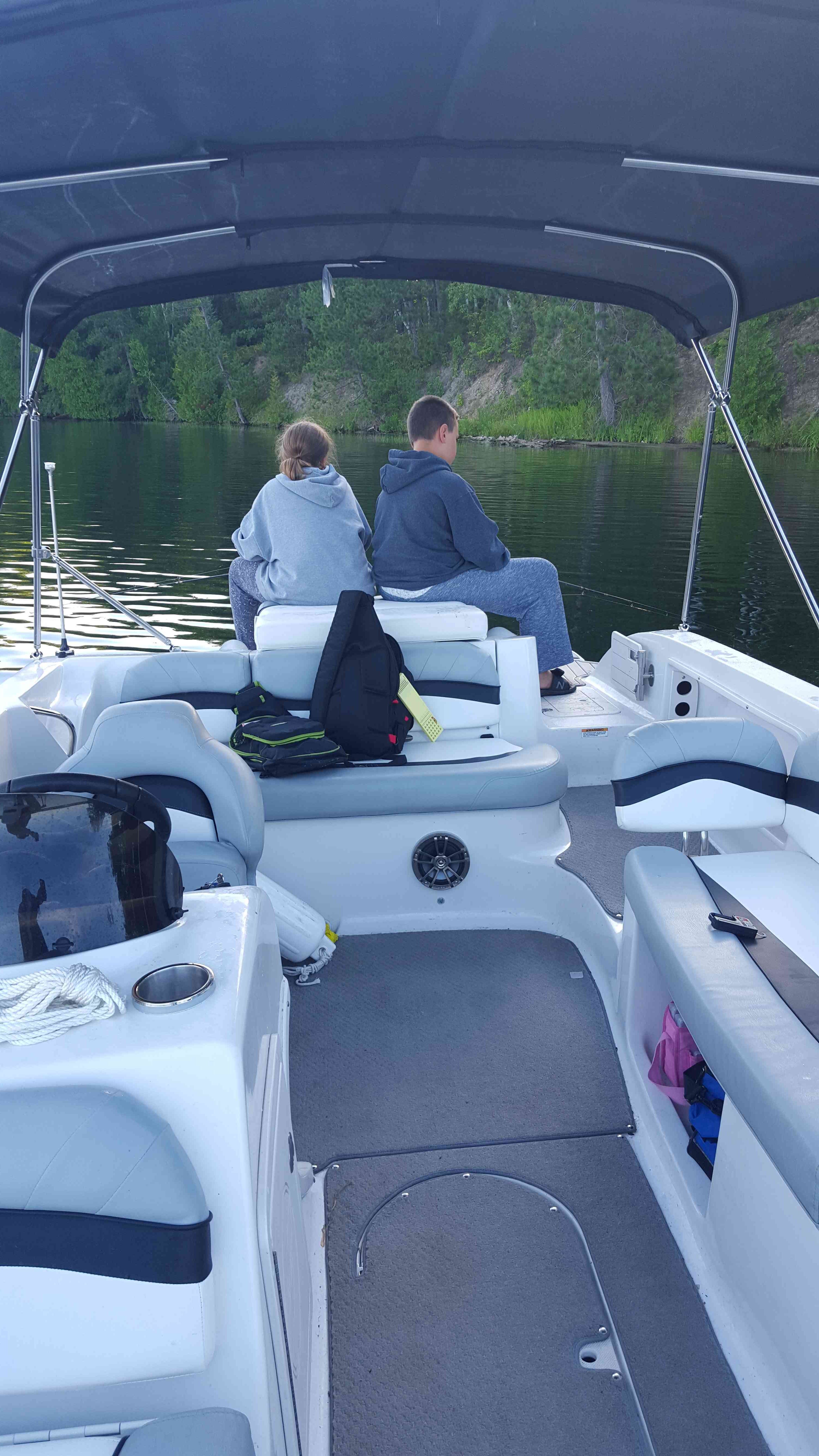 Two people relaxing on a 2015 Starcraft 2000 boat.