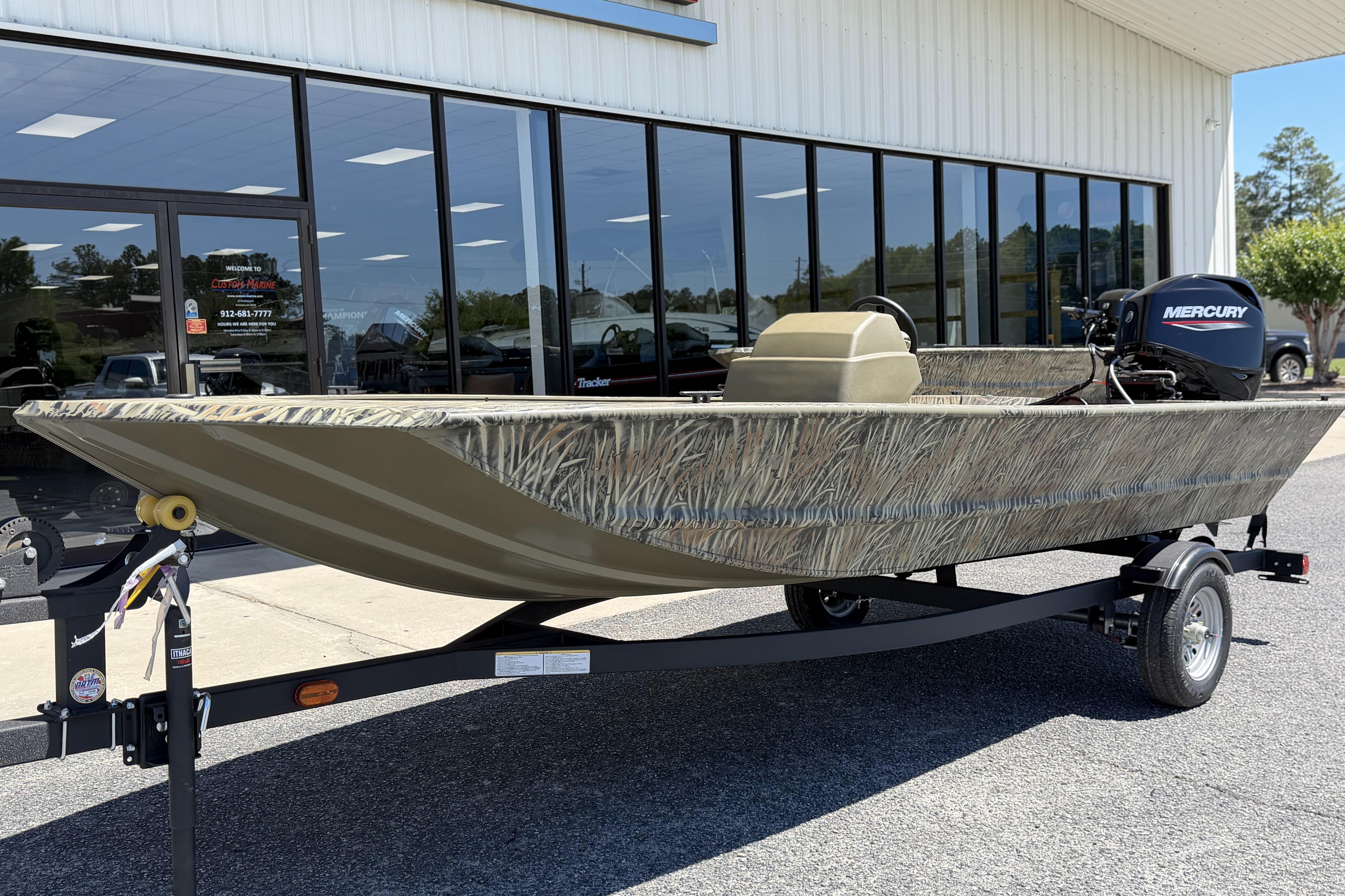 2026 Tracker Grizzly 1648 SC boat with Mercury engine on trailer, parked outside dealership.