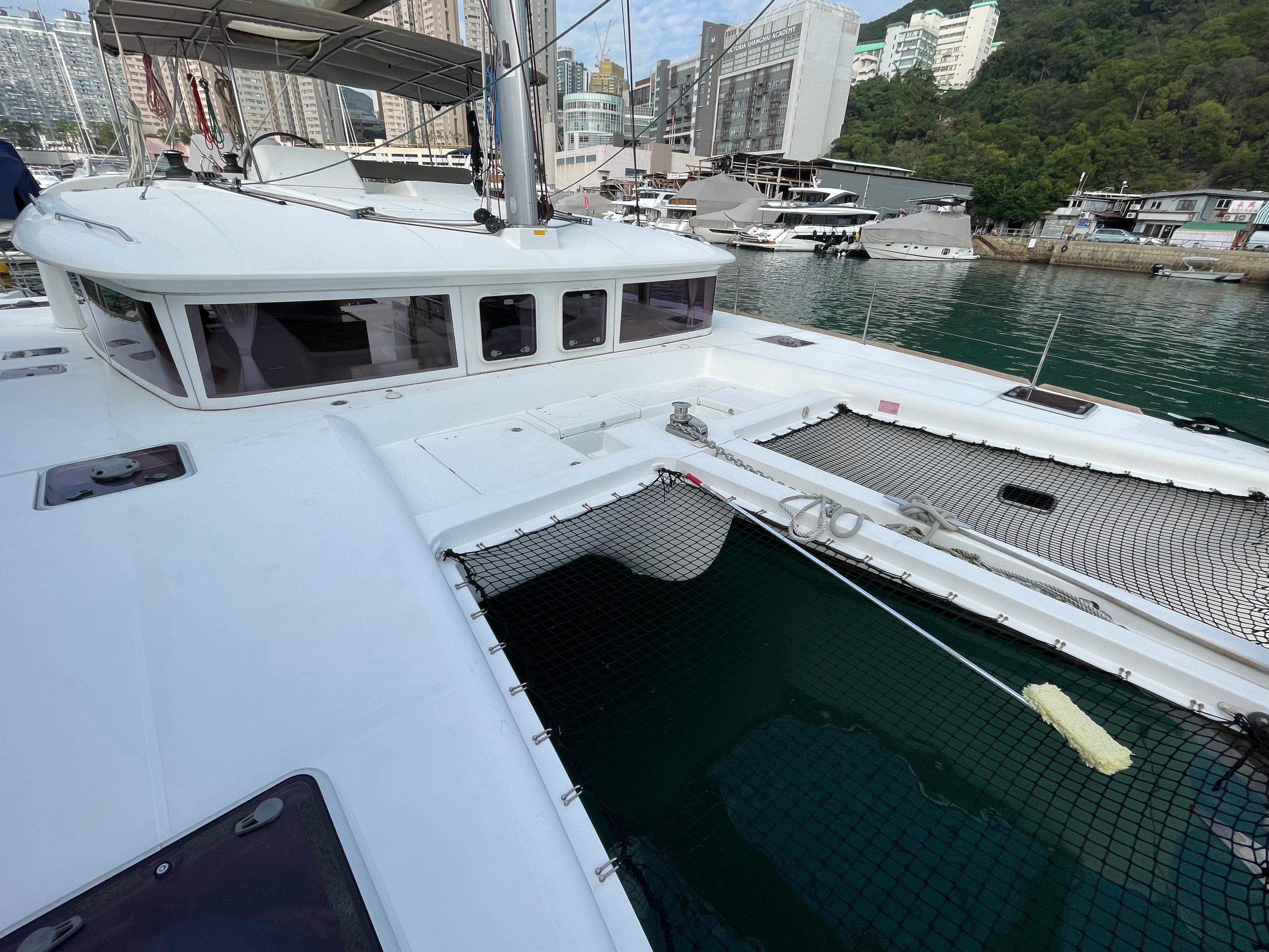 2014 Lagoon 450 catamaran docked in a marina with cityscape background.